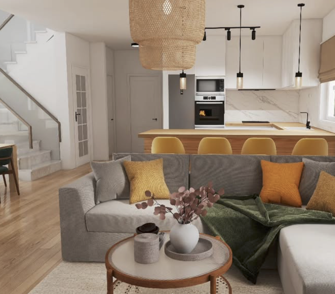 Living room and kitchen in an open floor plan with a sofa, yellow accent pillows, a coffee table with decorative items, and a kitchen island with yellow chairs. The kitchen has white cabinets, a marble backsplash, and pendant lighting.