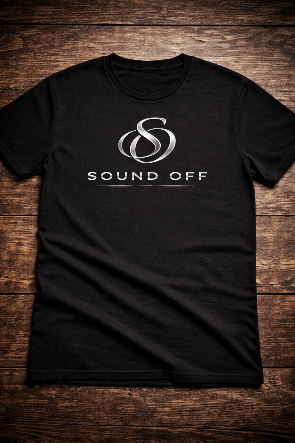 Black T-shirt with a silver logo and the words 'Sound Off' printed on it, laid flat on a wooden surface.