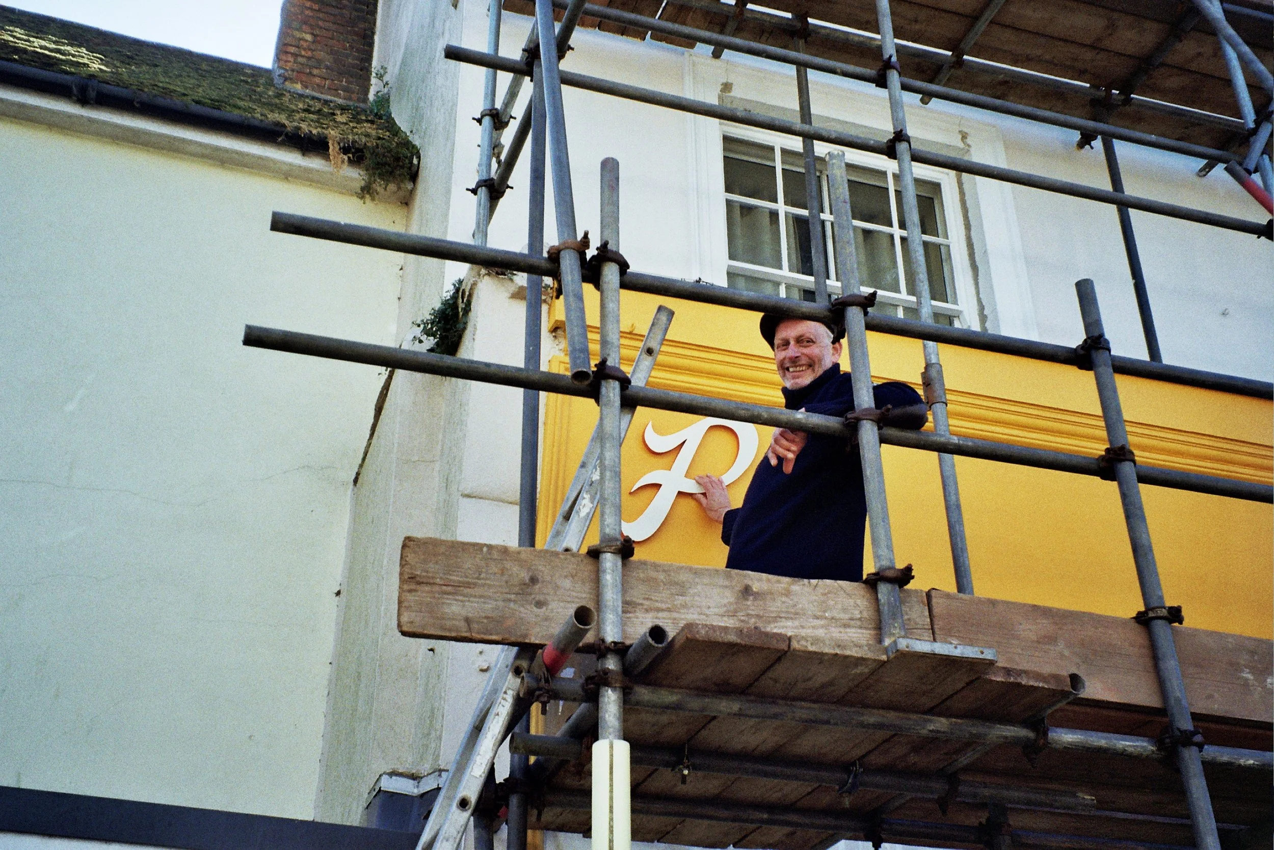 signwriters east sussex on scaffolding putting up the pats pizza sign