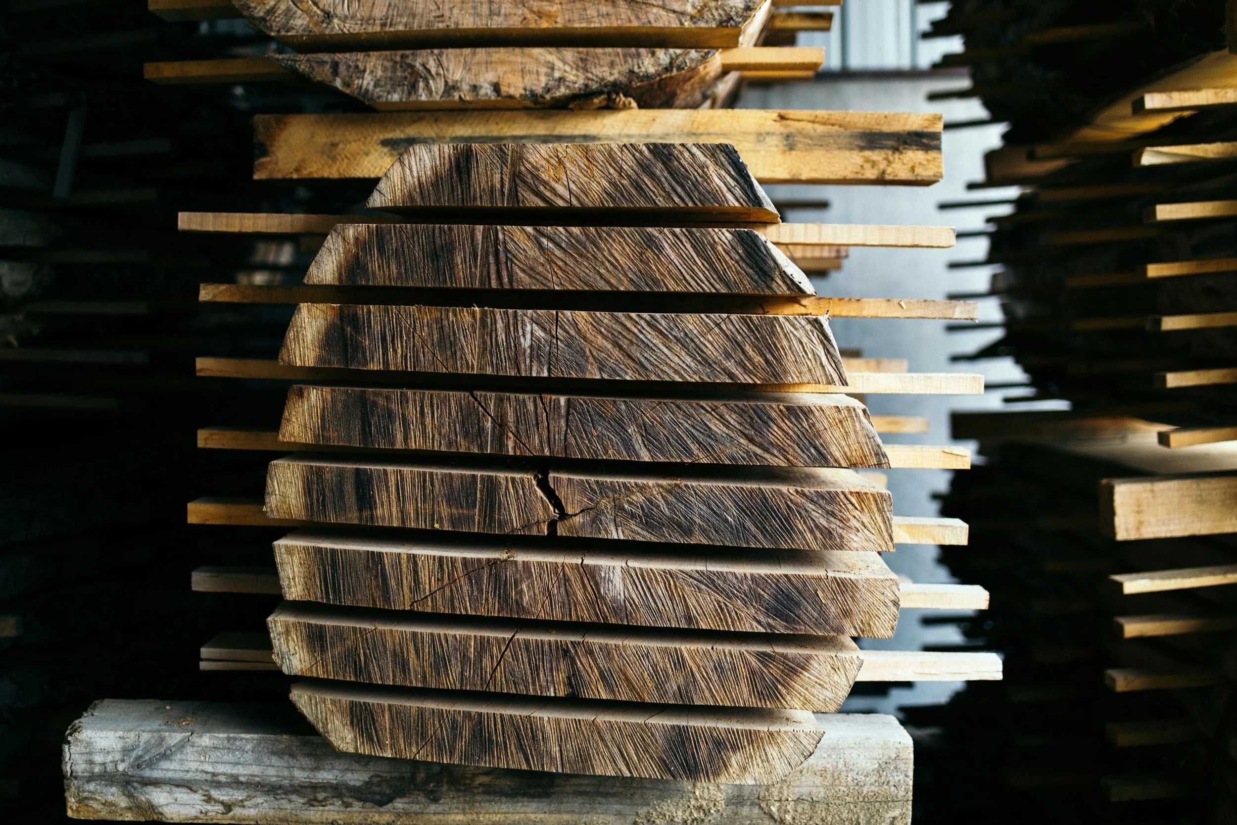 Stacked wooden planks in a workshop or lumberyard.