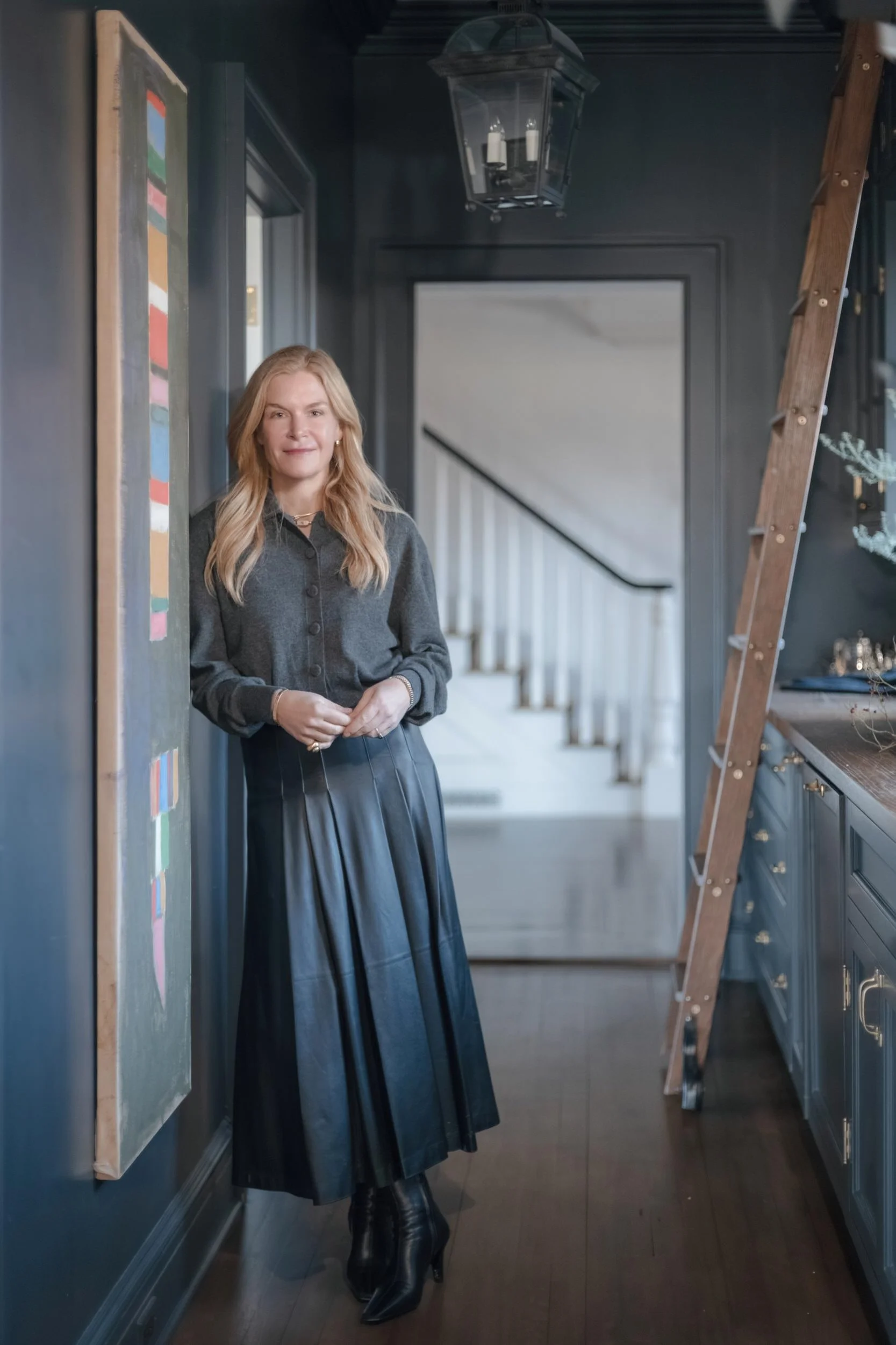 Art advisor Cecilia Wolfson standing in a curated hallway with contemporary artwork and decorative objects