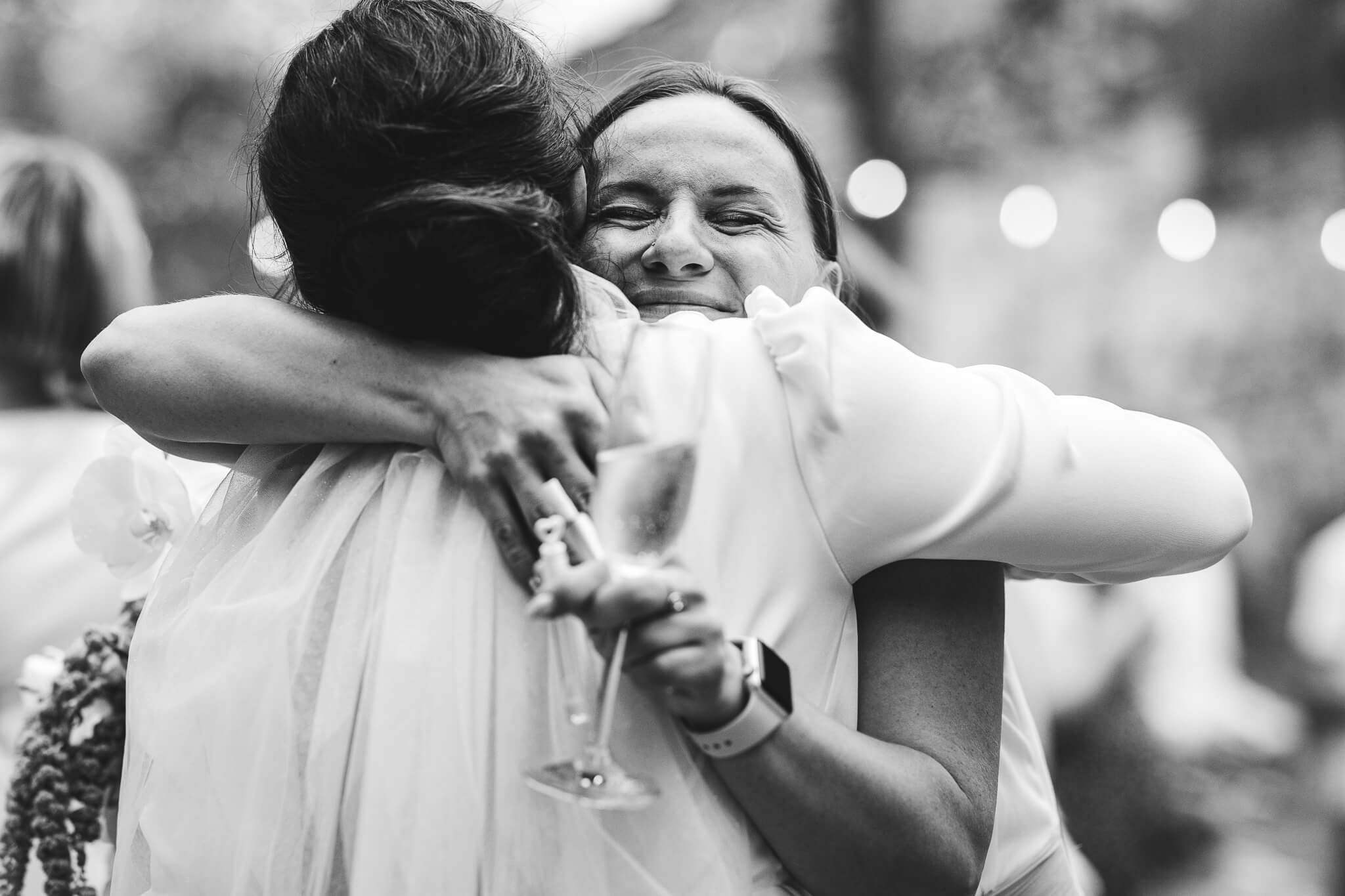 A deeply moving moment: the bride and a loved one embrace, candid wedding photography by Cécile Wedding