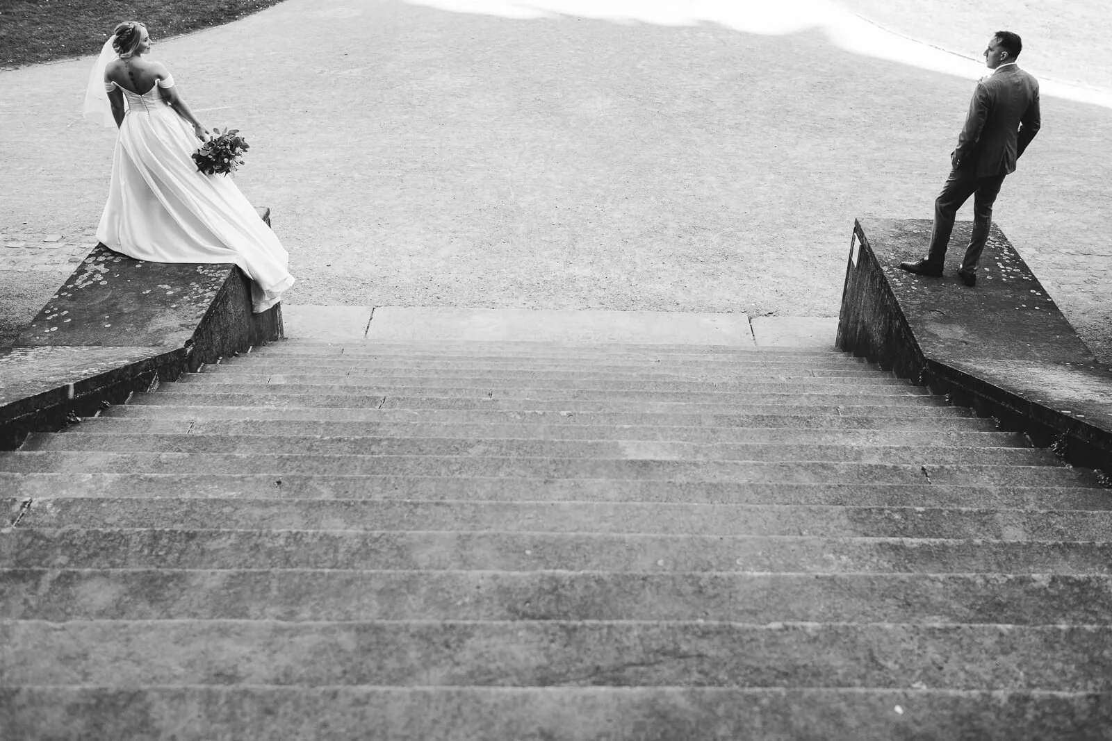 A newlywed couple in black and white on a stone staircase, fine-art wedding photography by Cécile , Provence