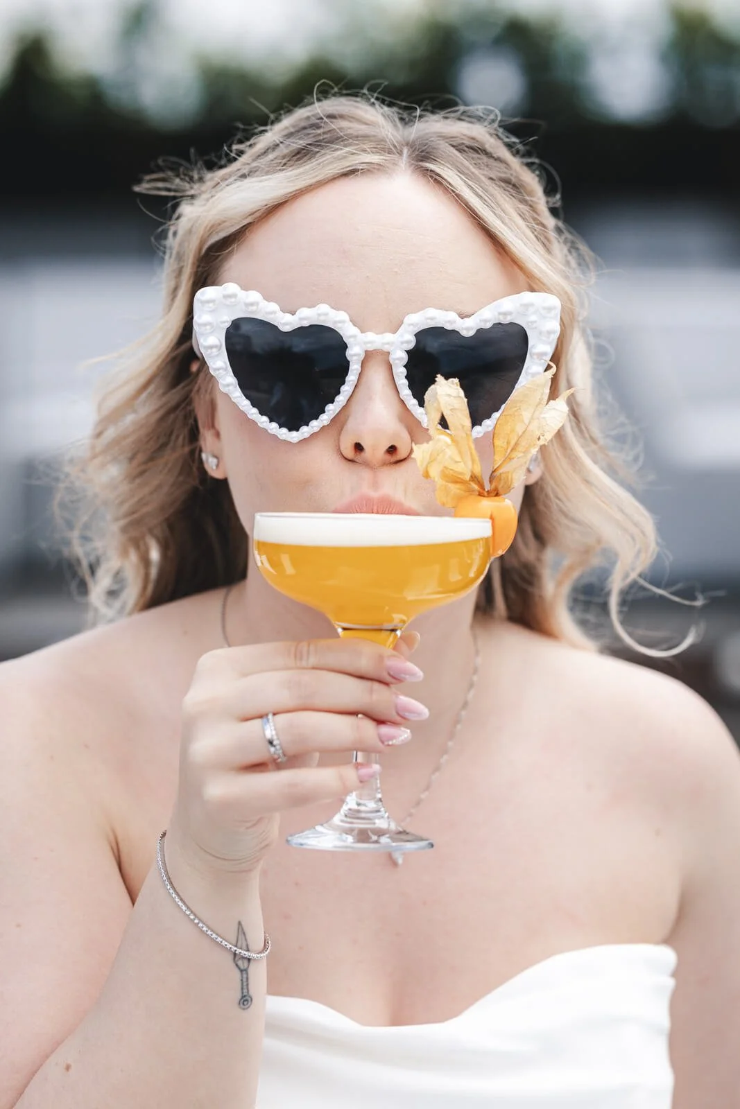 A spontaneous and joyful bride enjoying a cocktail; high-end candid and editorial wedding photography by Cécile Wedding, featuring fine-art and cinematic styles