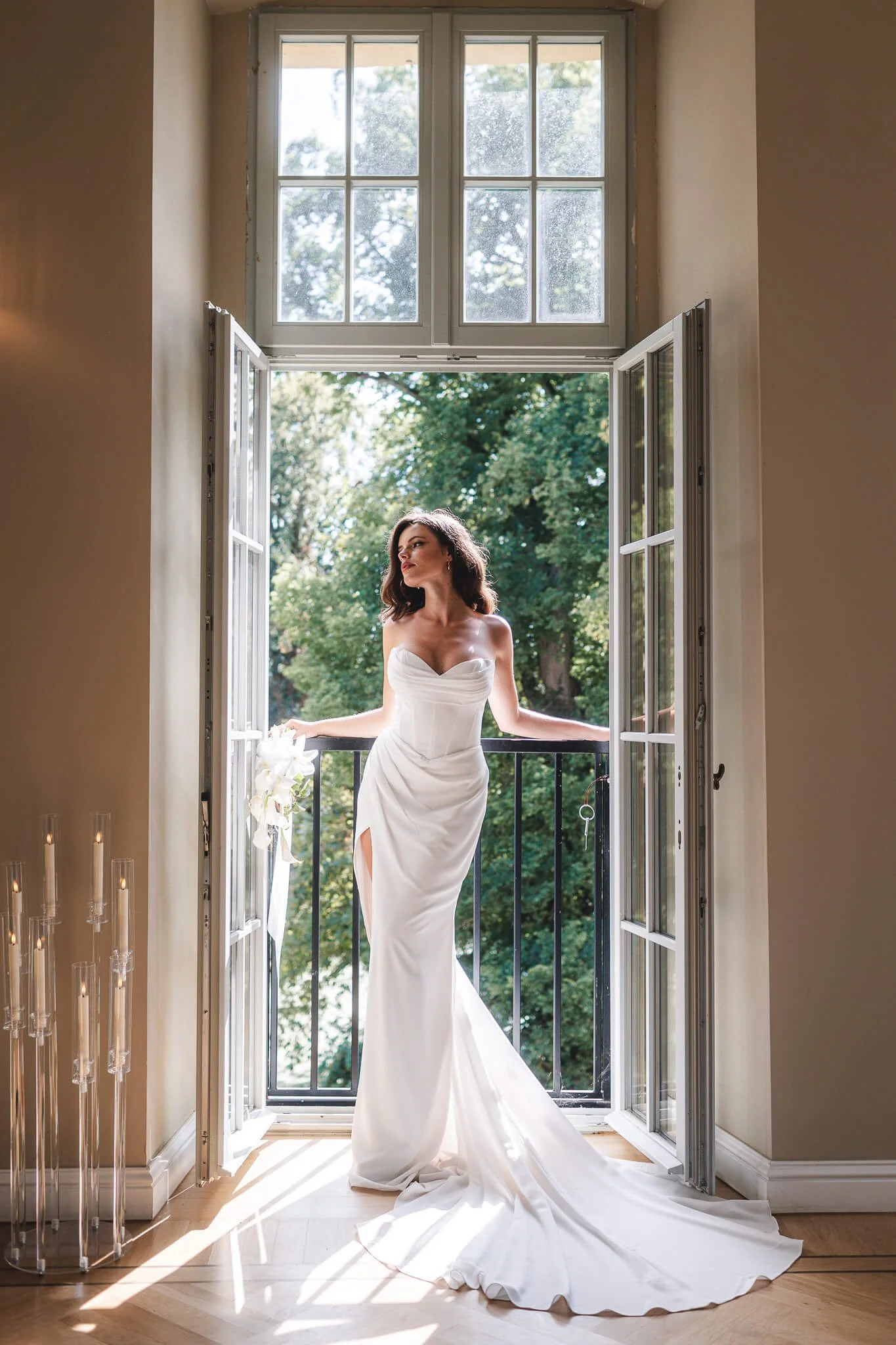 A luminous portrait of a bride leaning against a window in a fit-and-flare dress, photographed by wedding photographer Cécile : fine-art weddings, luxury weddings, Provence, Paris, and destination weddings