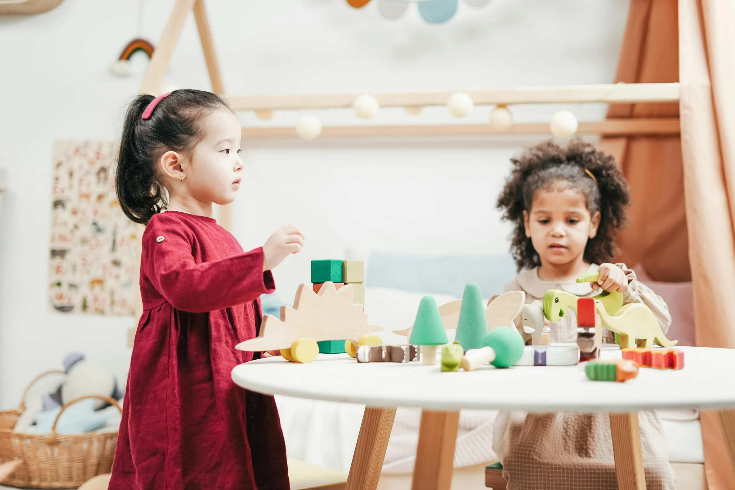 two young girls playing with wooden blocks