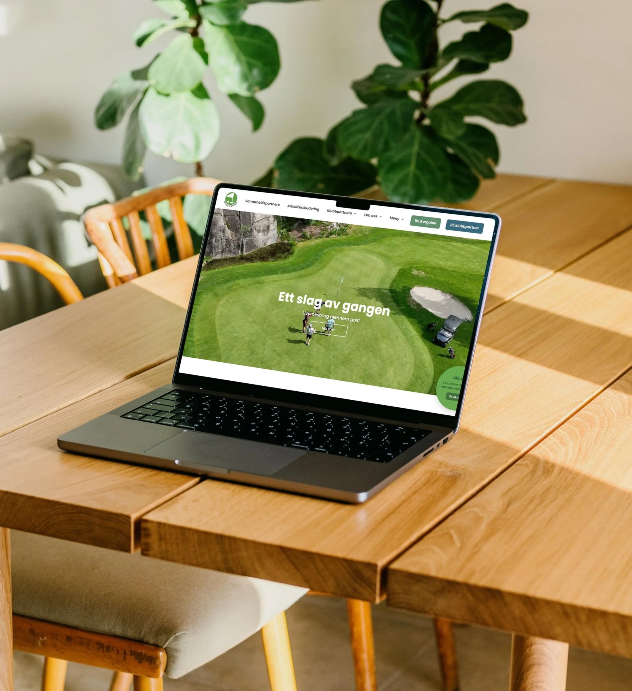 Laptop on a wooden table displaying a golf course website with text in Norwegian