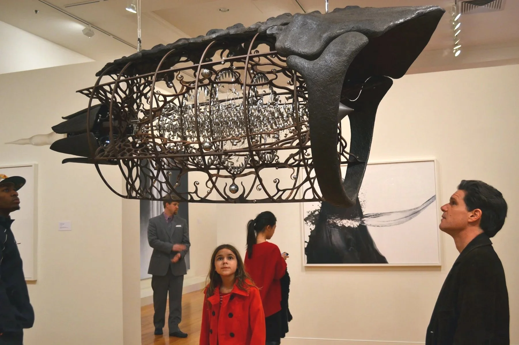 Child closely observing artwork in a museum exhibition.