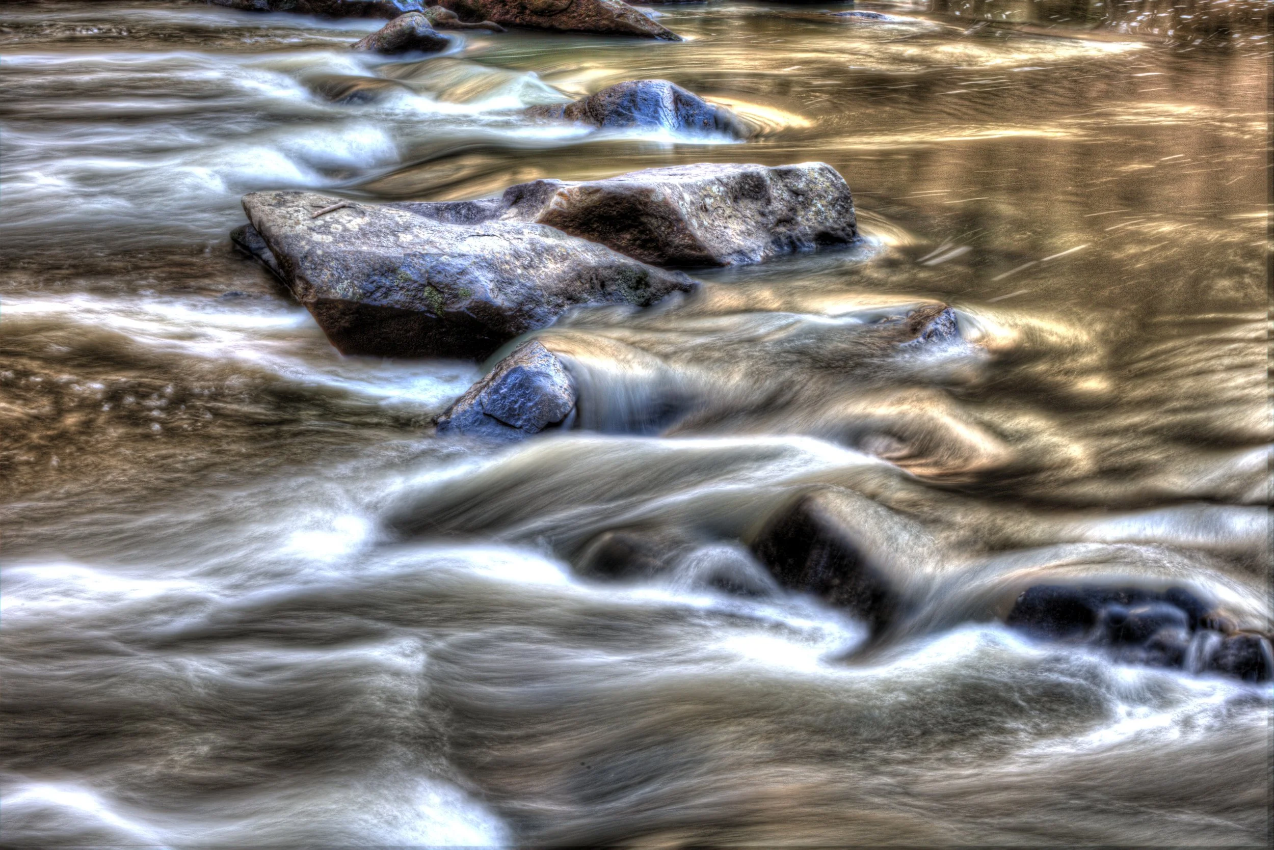 Slow exposure of water flowing in Rock Creek Park in Washington, D.C. over rocks in a river.