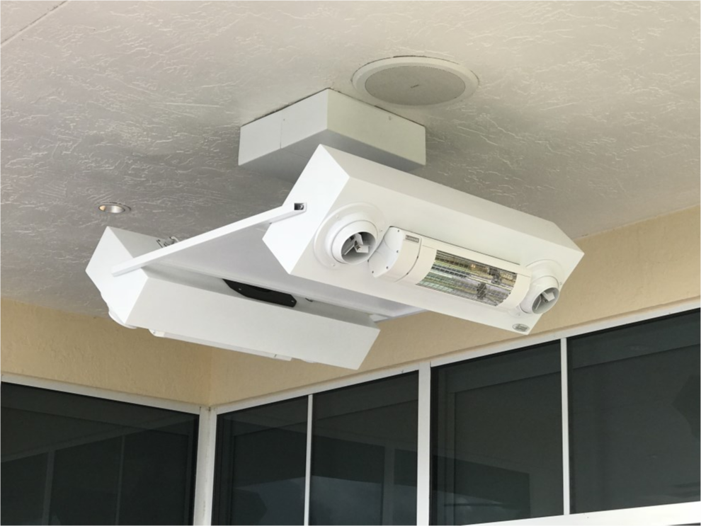 Ceiling-mounted combination of a projector and a heater in an indoor space.