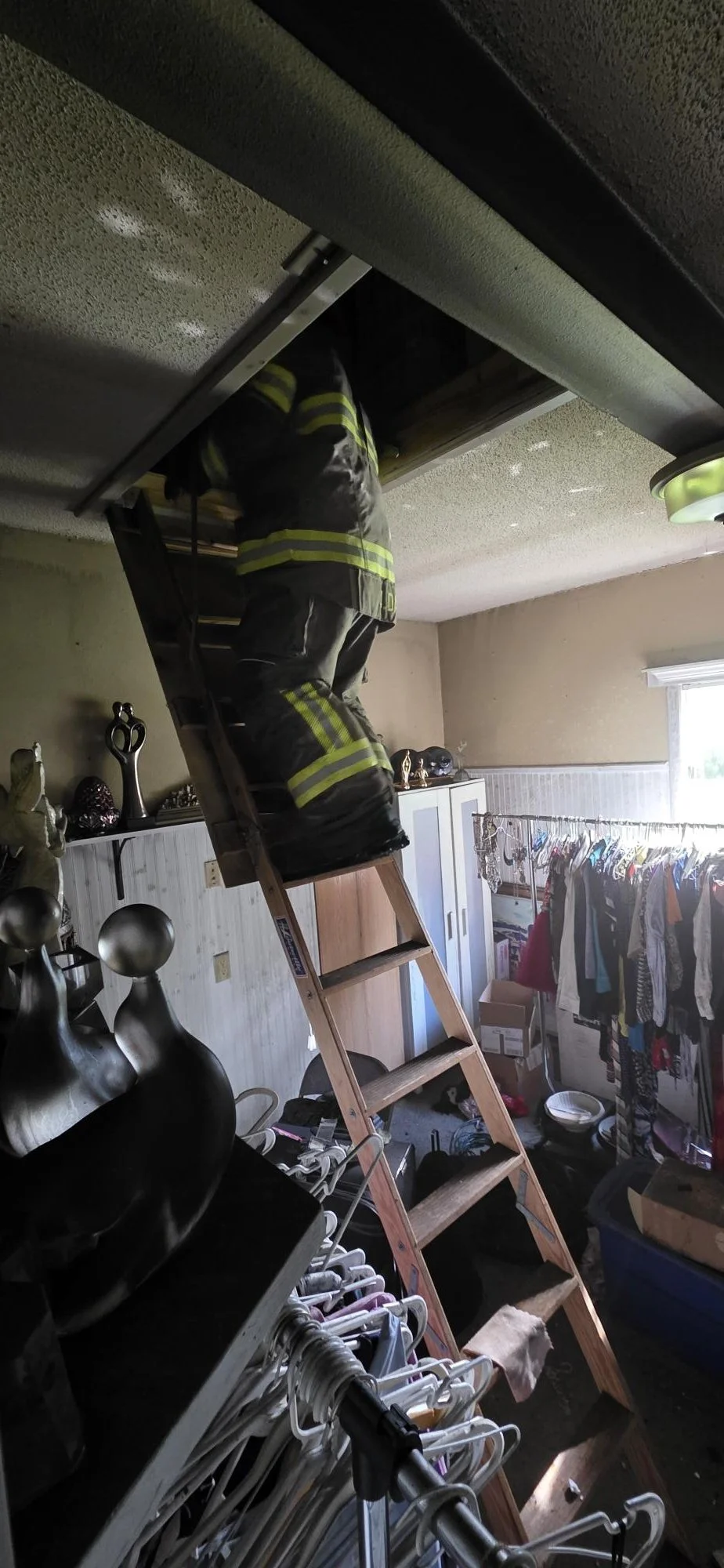 Fire fighter on attic access ladder
