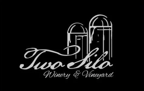 Logo for Twa Lila Winery & Vineyard with two stylized vineyard towers.