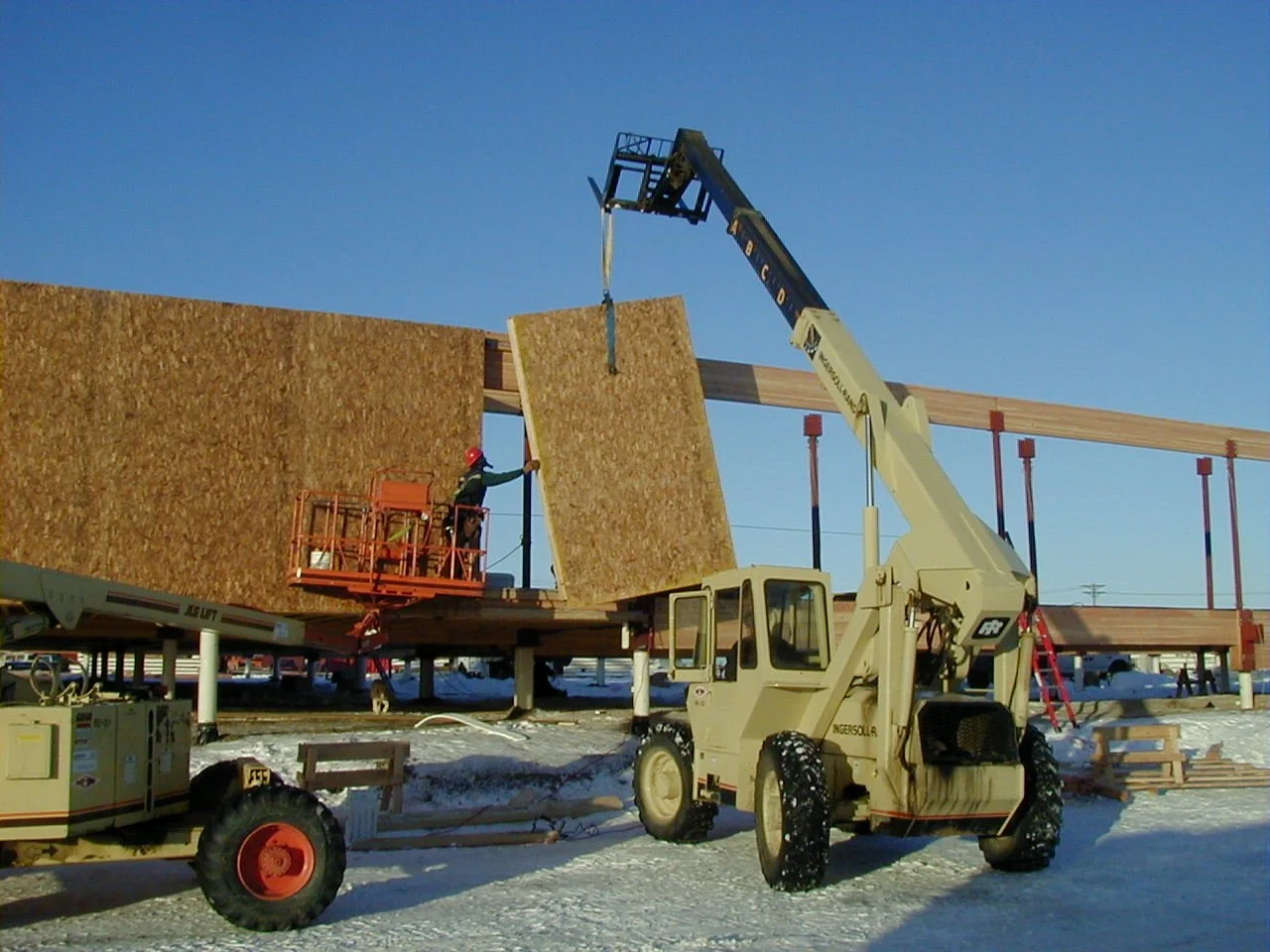 SIP panels staged on a job site showing the structural foam core and OSB facing layers typical of residential SIP construction.