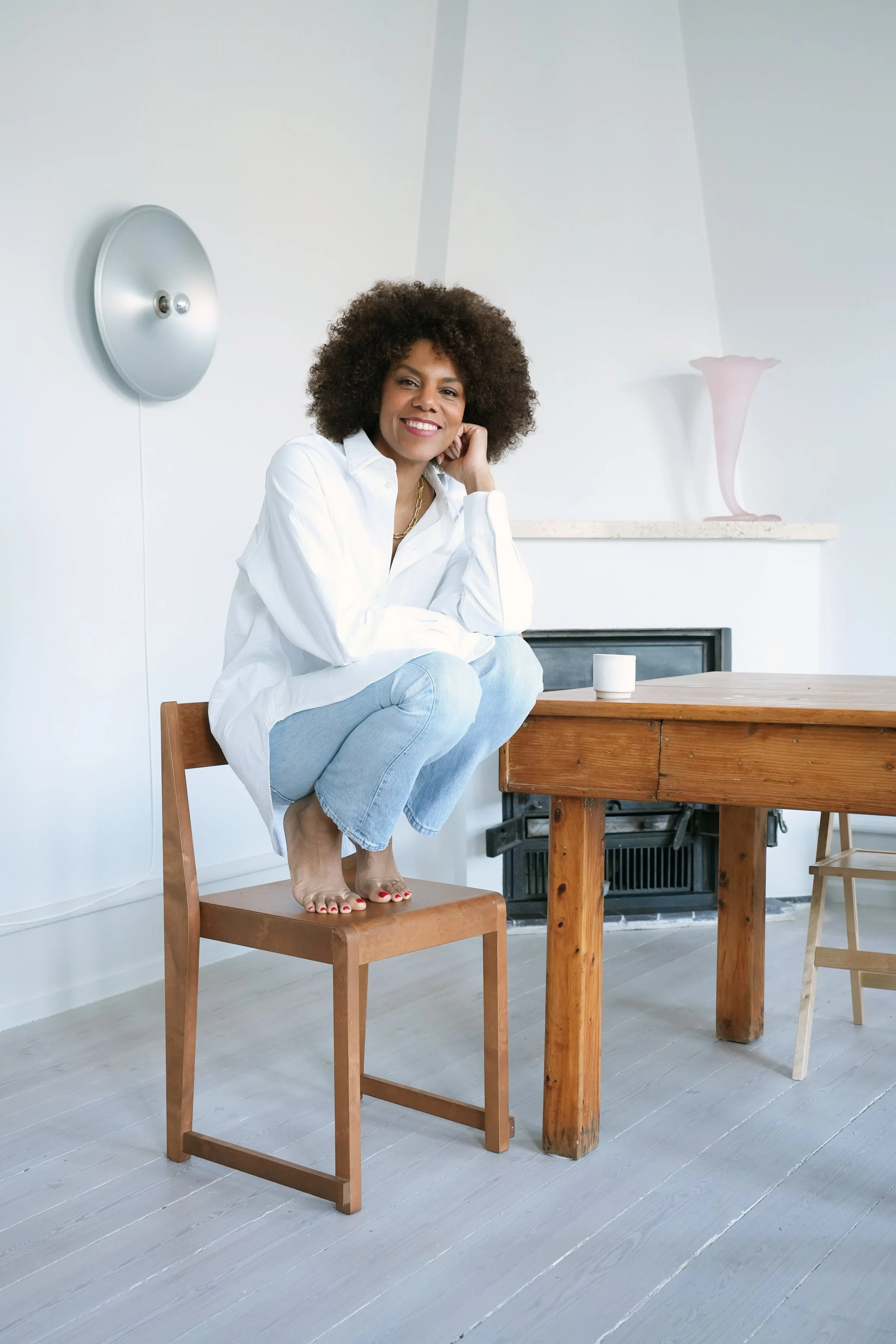 Yvonne Koné in her Copenhagen apartment and studio wearing a LAFINE cotton shirt. Selecting materials and understanding the potential of existing environments, working between Copenhagen and Tuscany with specialized makers and craftsmen.