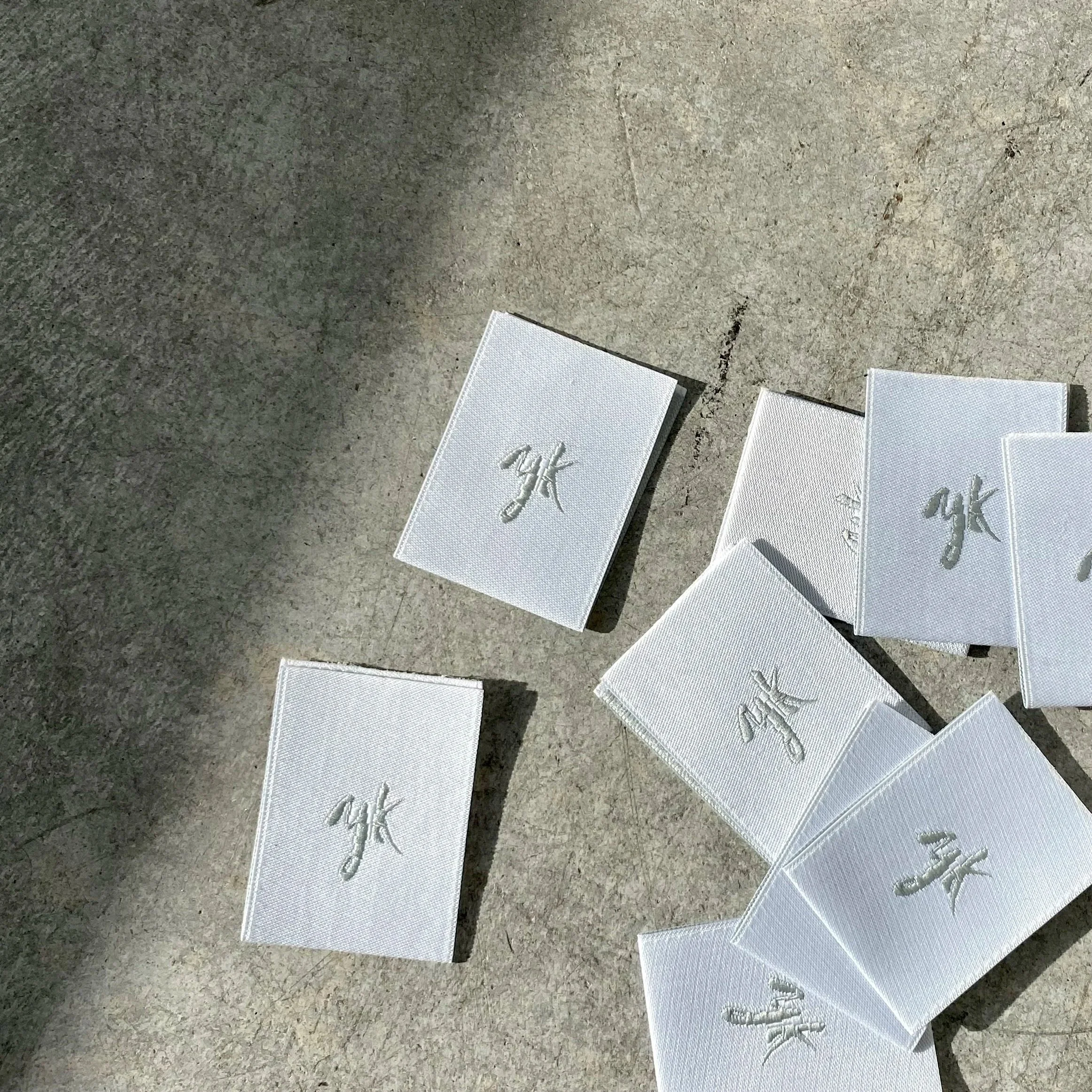 Close up of the woven YK signature label designed by Yvonne Koné and made in Italy for tailor made curtains and other interior textile products.