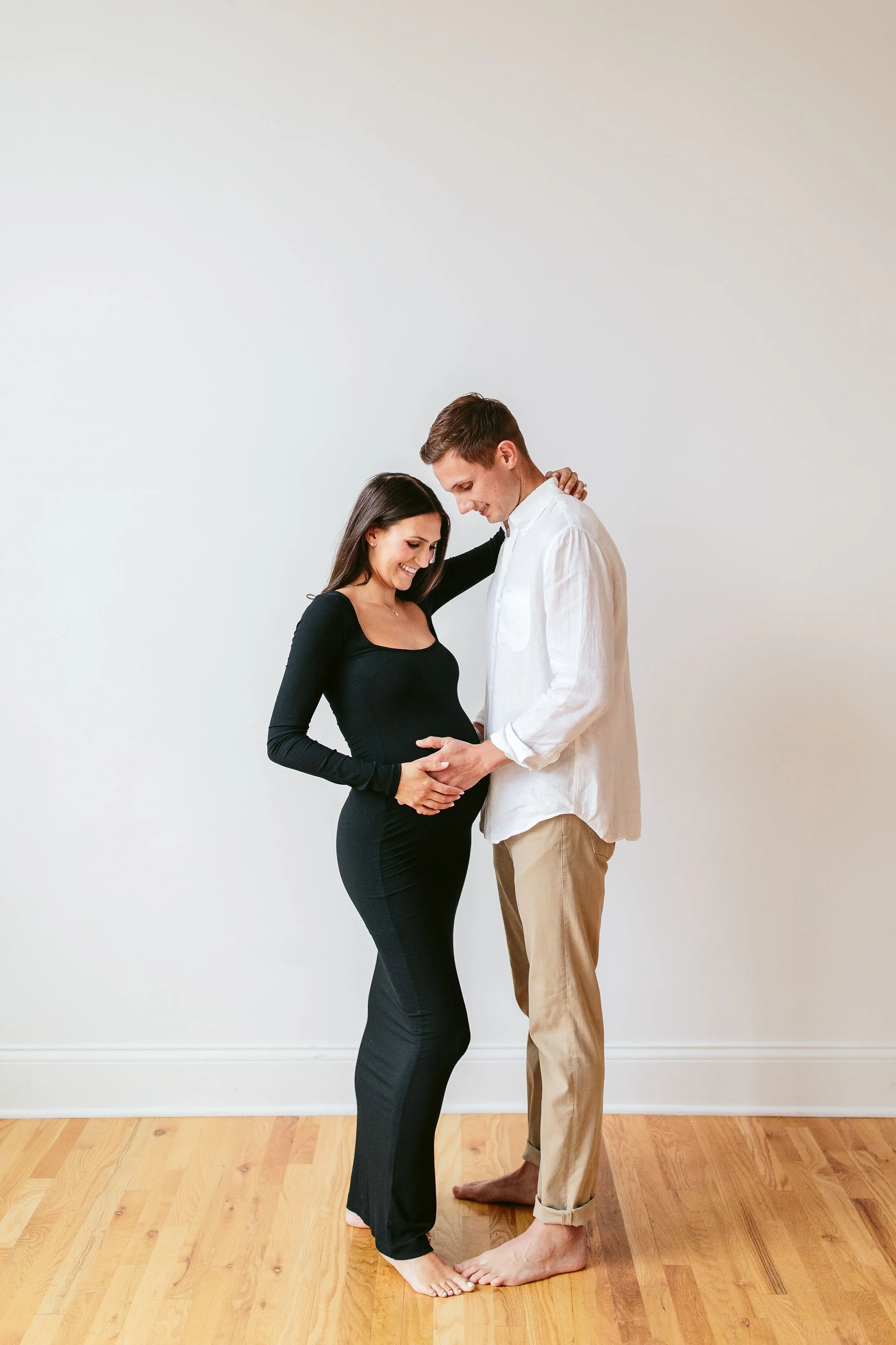 Parents in white clothing for a maternity session