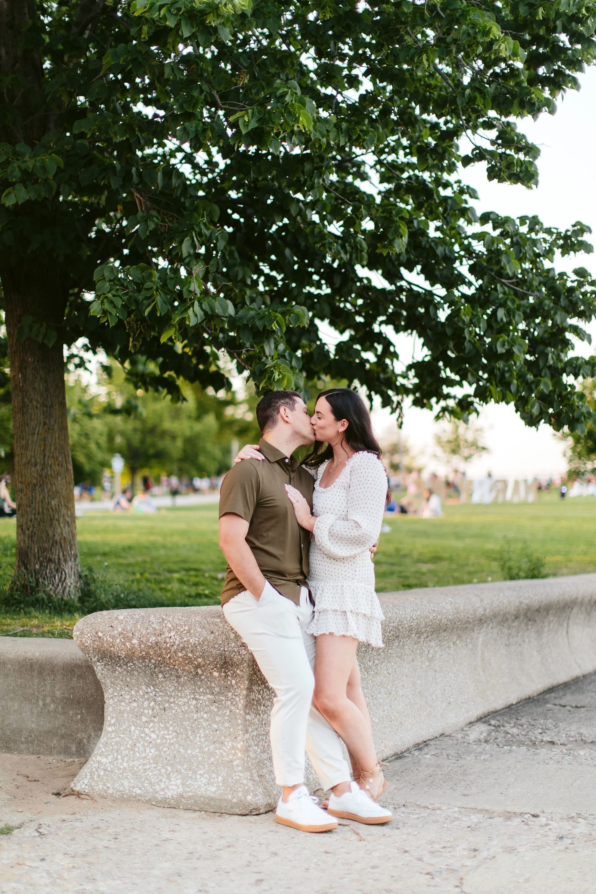 Engaged couple kissing under tree at North Ave Beach