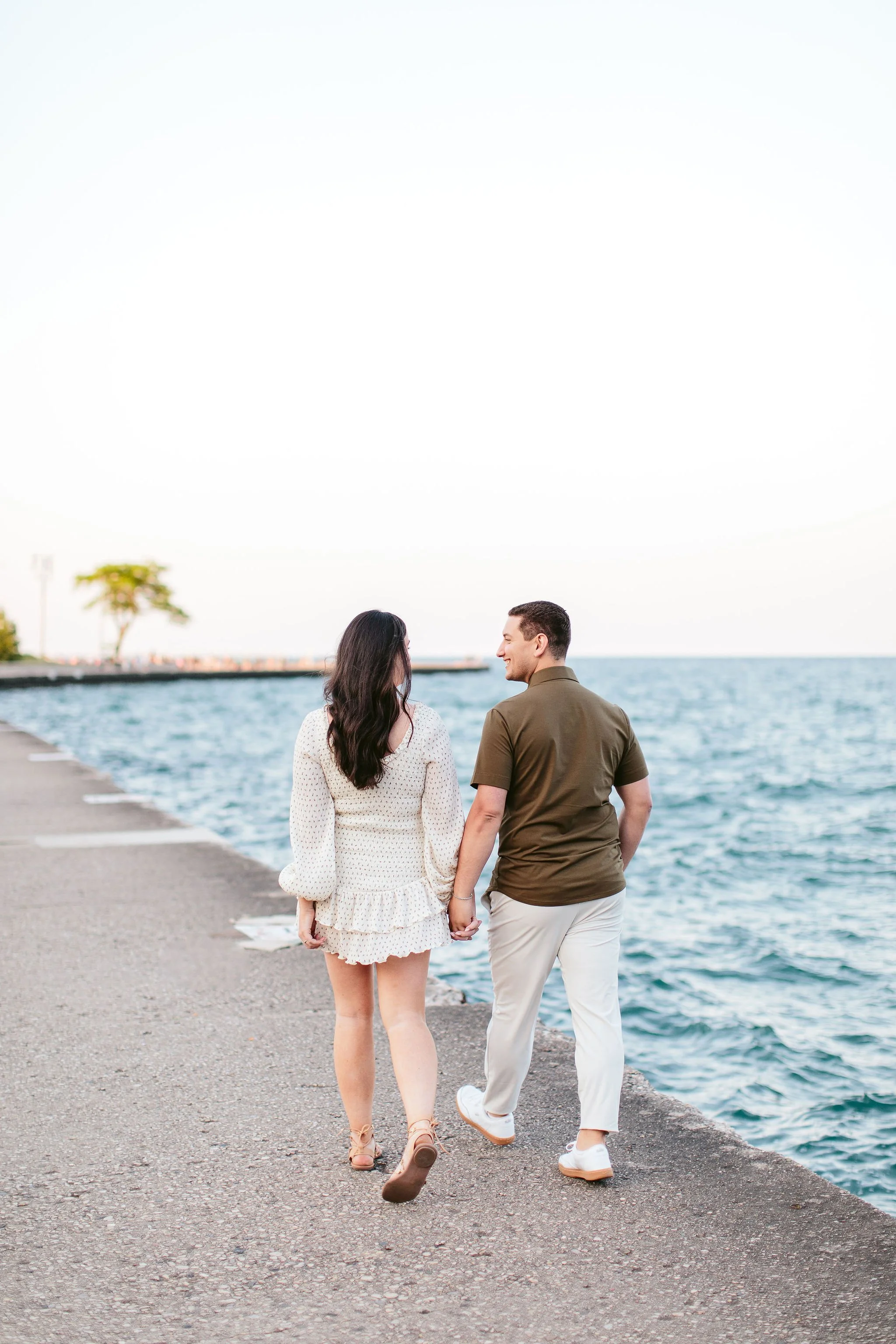 Engaged couple walking away from camera during North Ave Beach engagement session