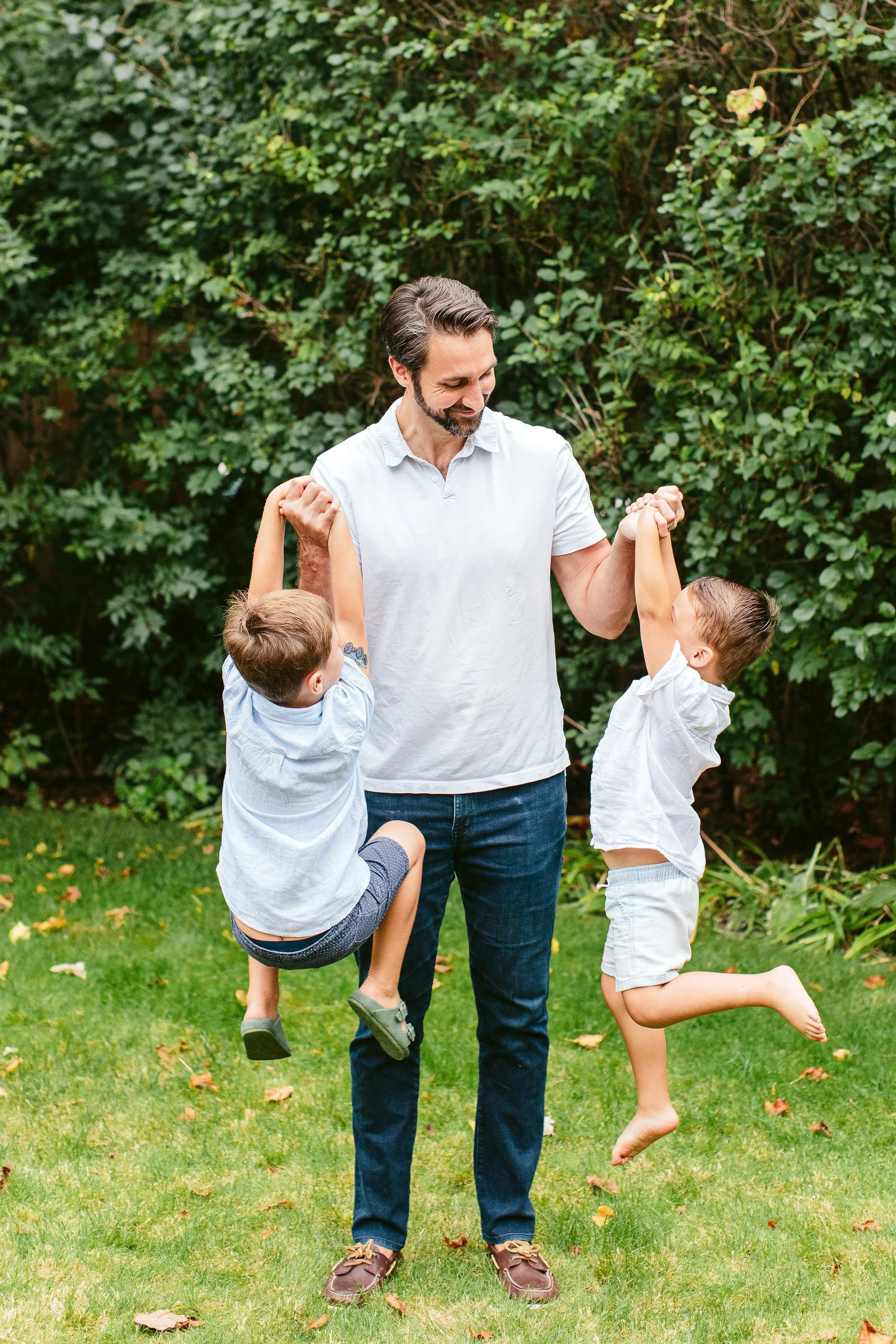father lifting two sons during portrait session
