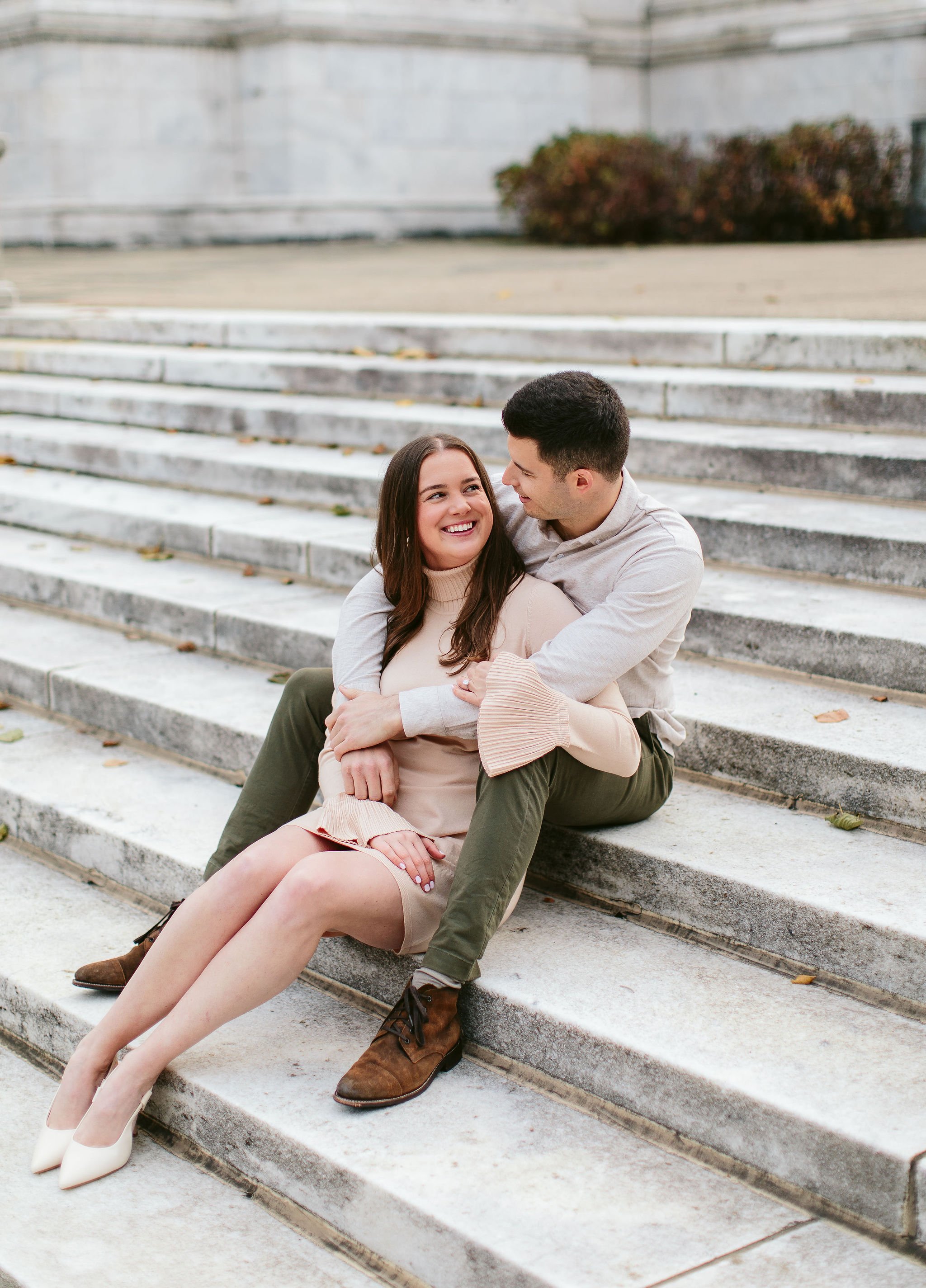 young couple sitting on the field museum stairs during engagement session