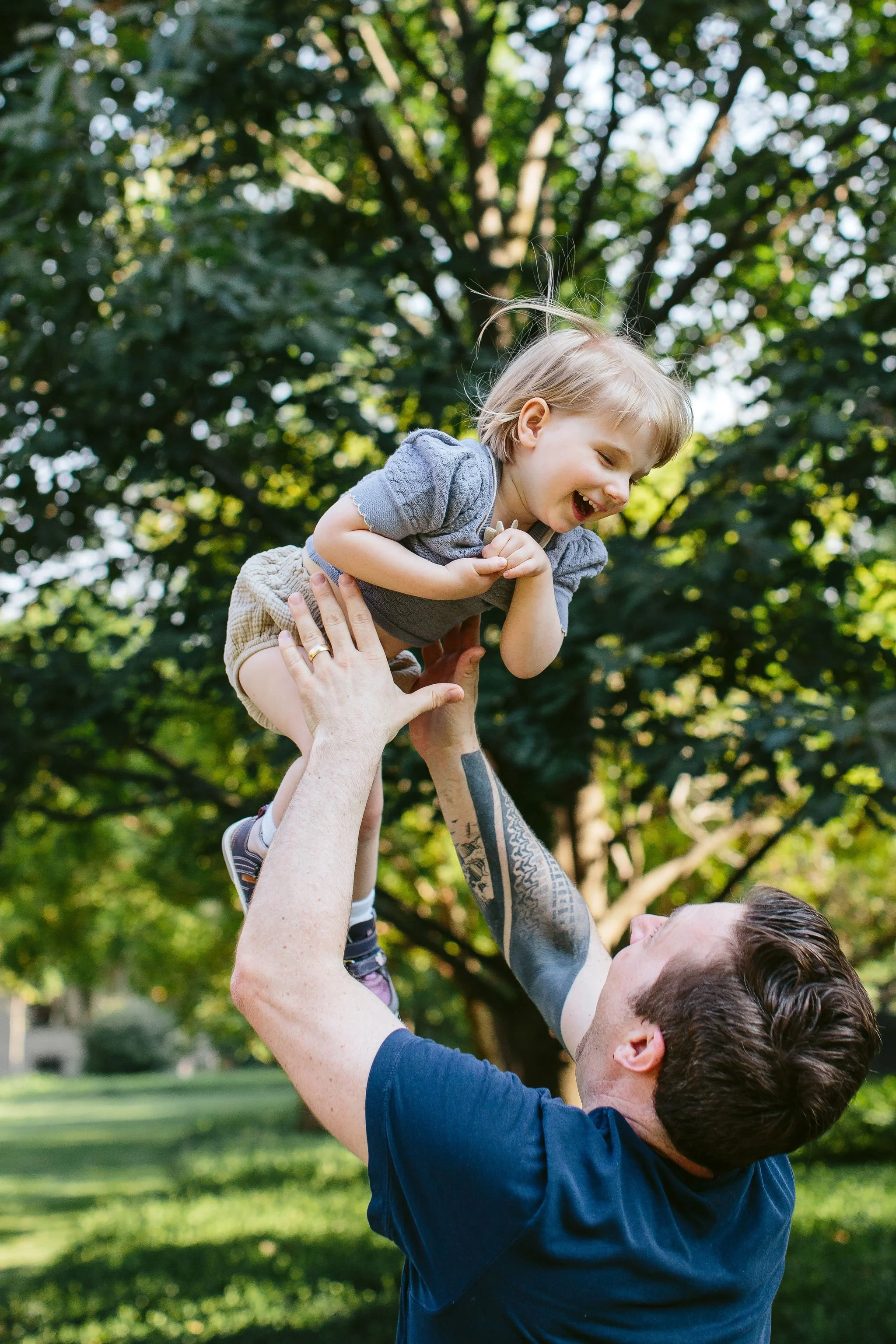 dad throws his daughter in the air and catches her for a portrait