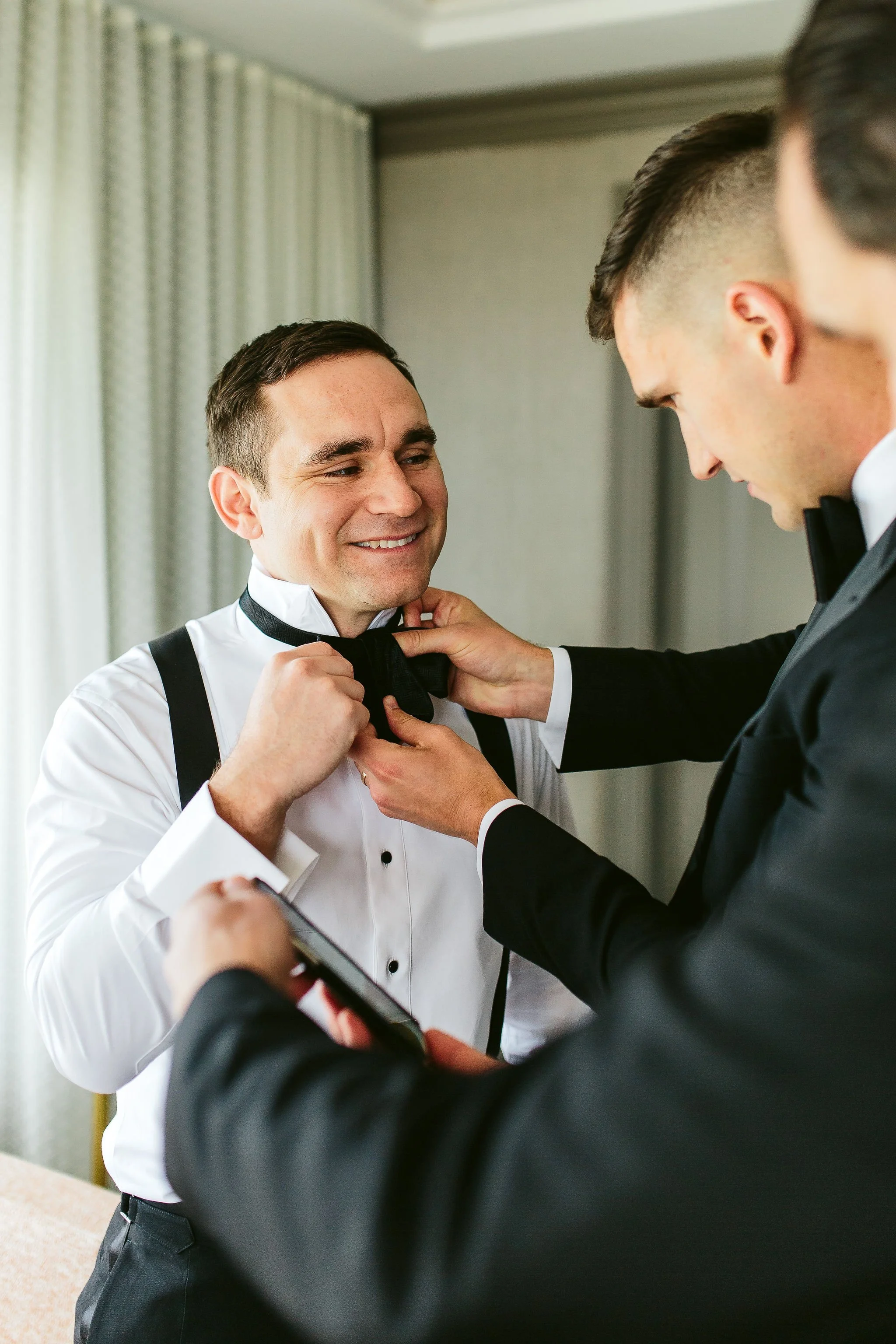 groom getting bowtie on chicago wedding