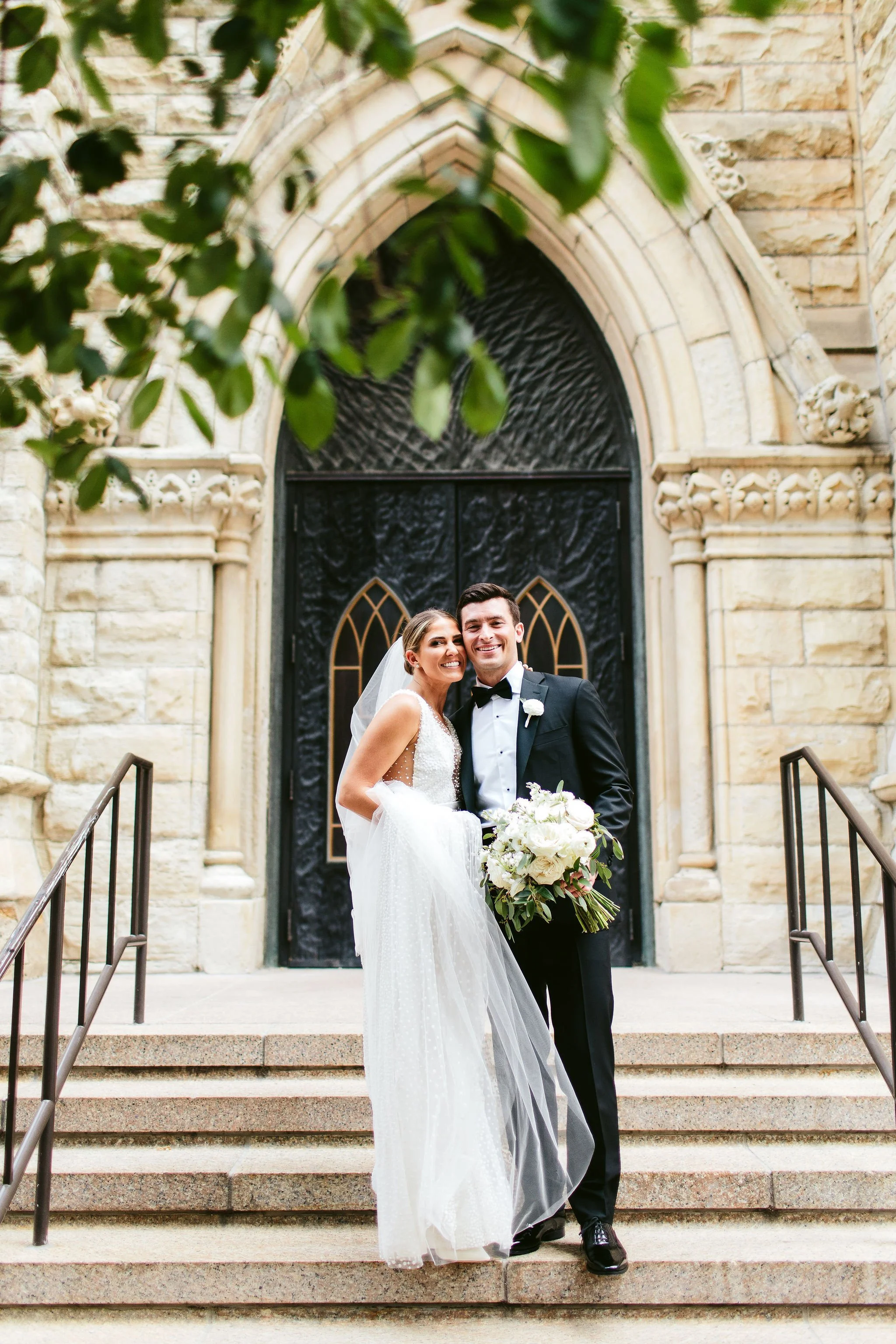 bride and groom portrait on church stairs
