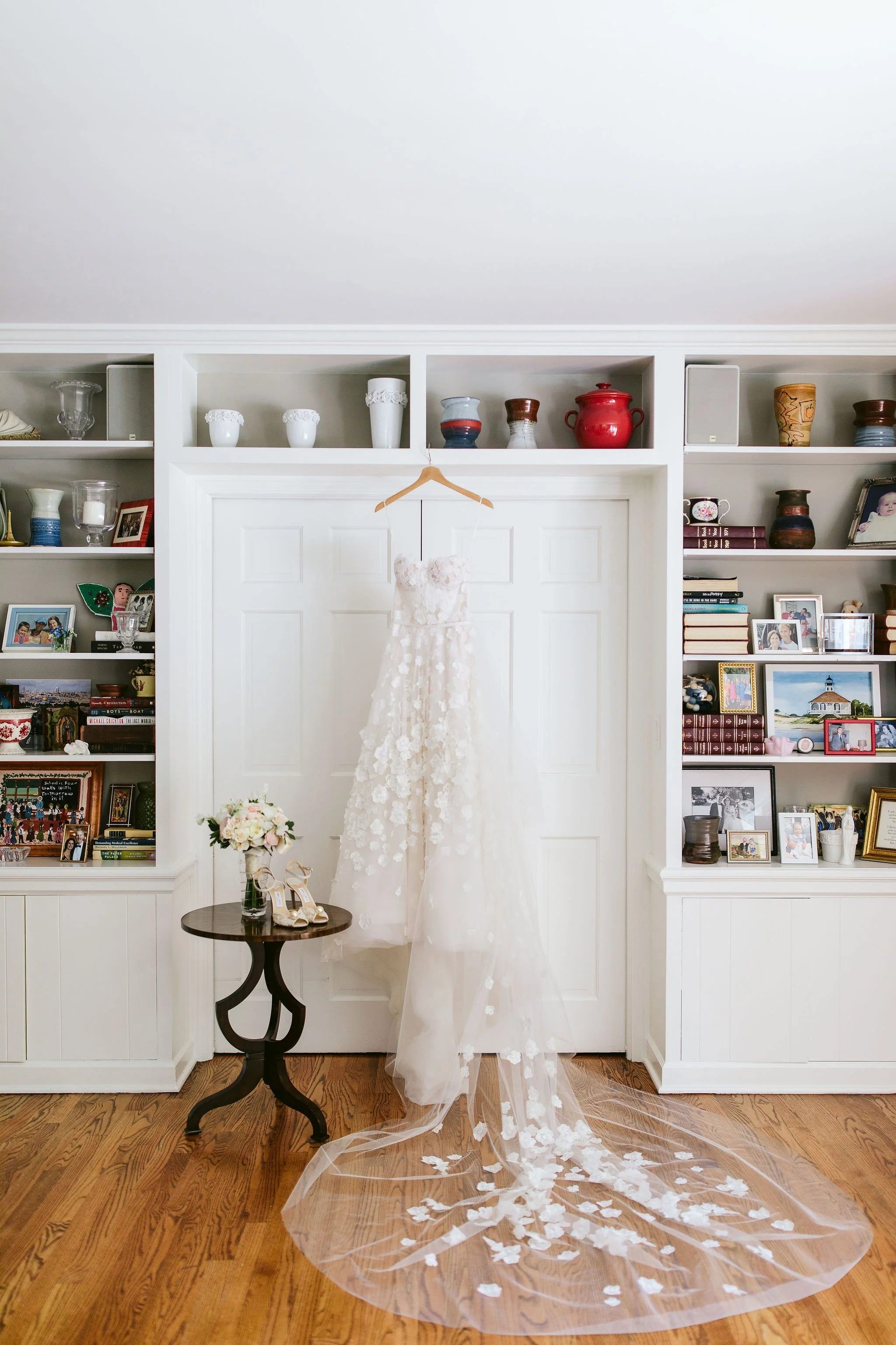 wedding dress hanging on bookshelves