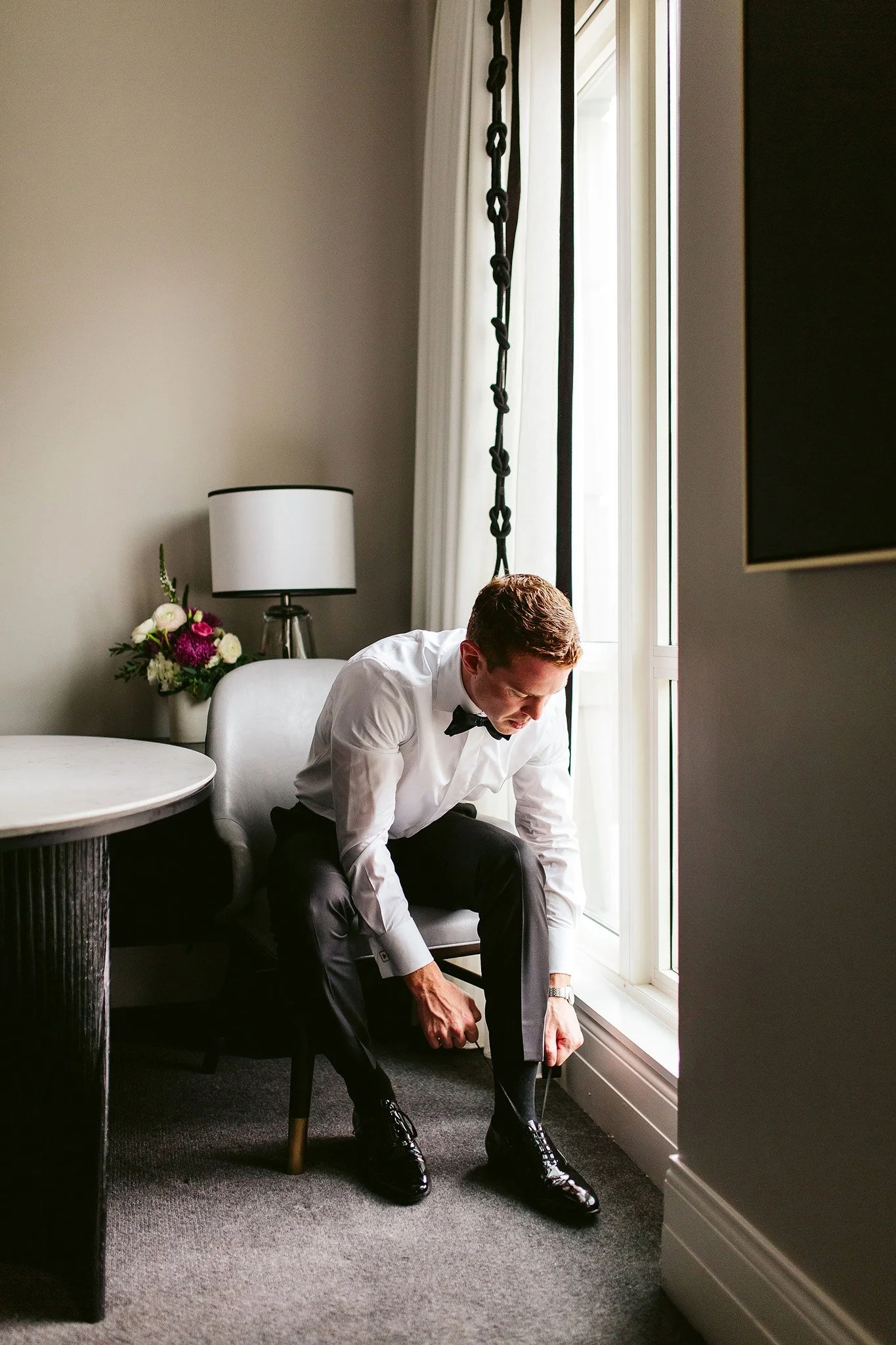groom getting ready with window light
