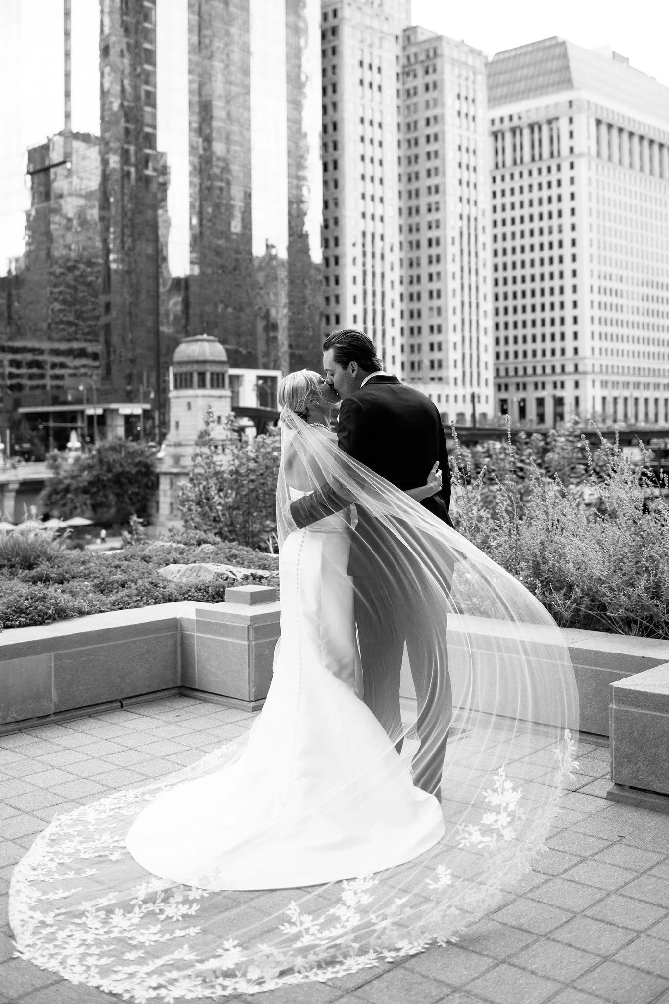 black and white photo of bride and groom on riverwalk