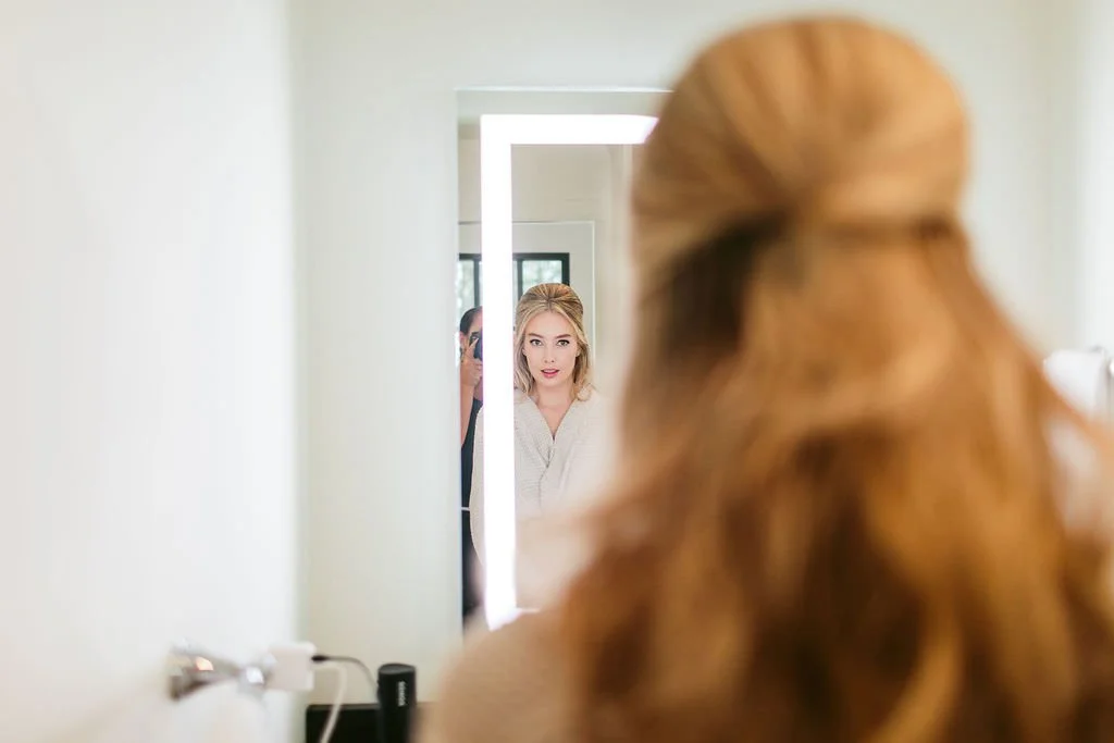 bride getting ready in mirror