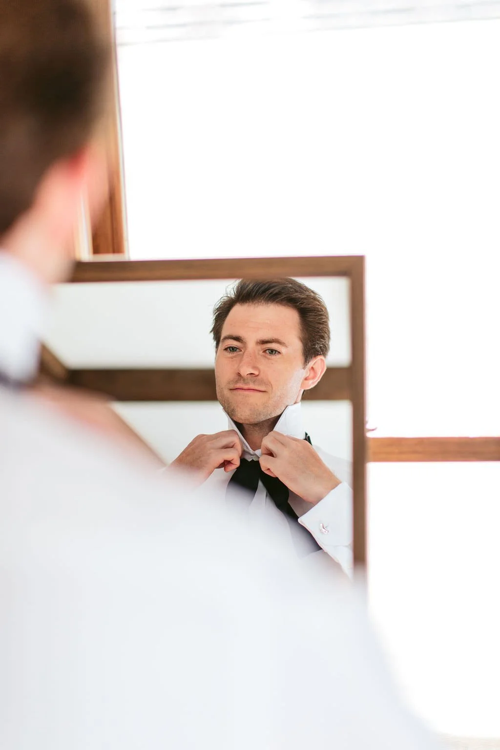 groom getting ready in mirror