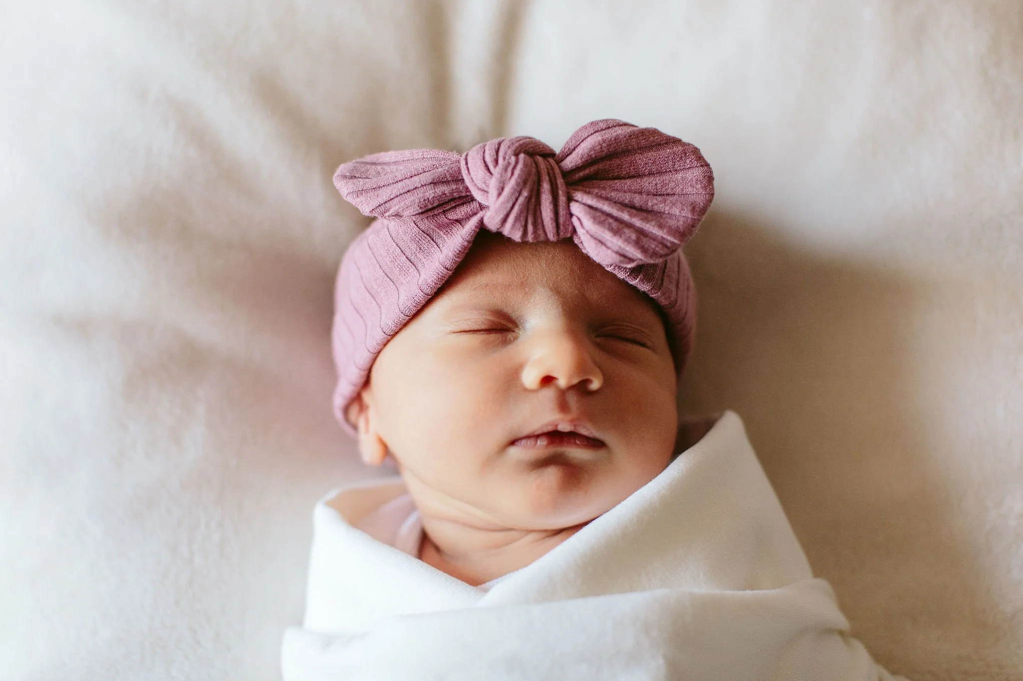newborn baby with pink bow
