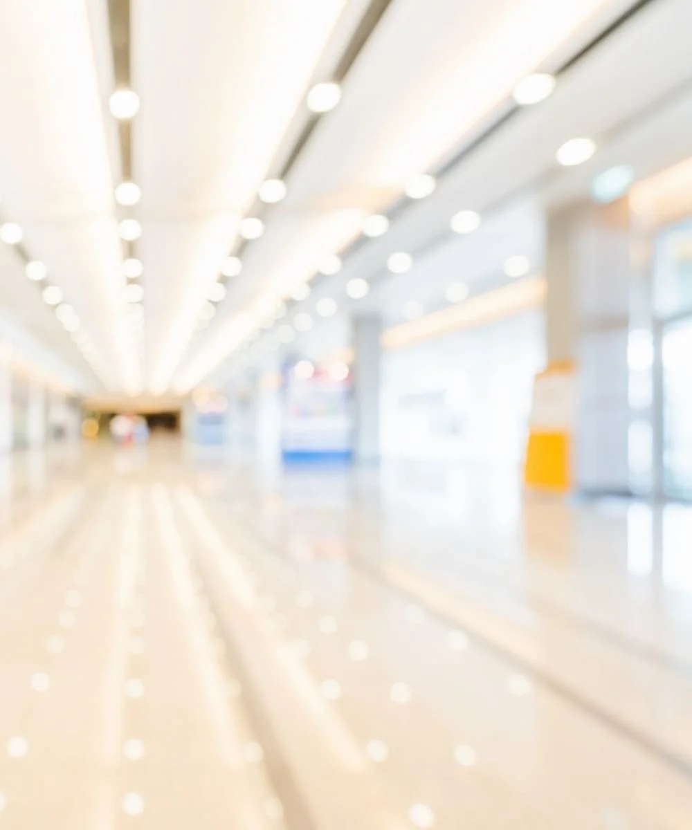 blurry image of a large hallway of brightly lit nondescript commercial space