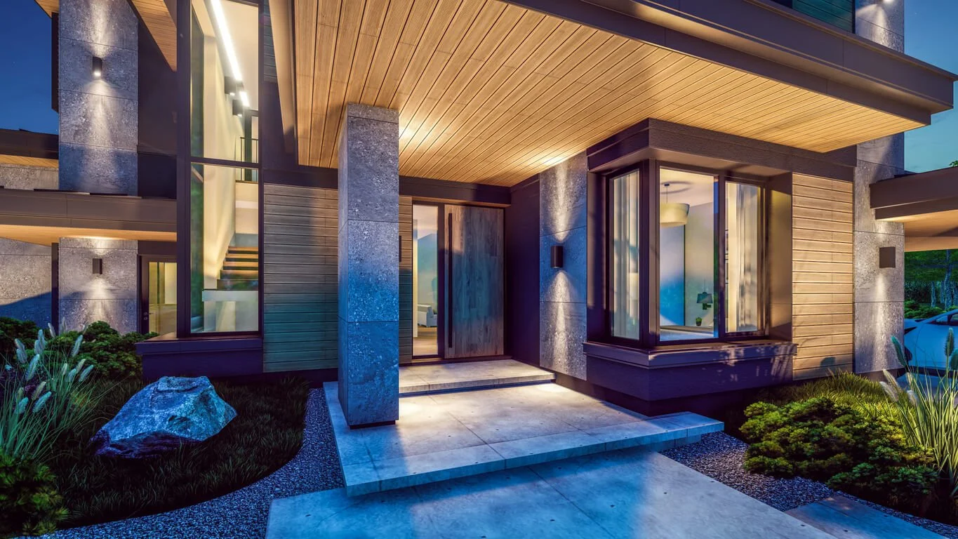 Exterior of a luxury modern home at night with landscape lighting and interior lighting design seen through the windows