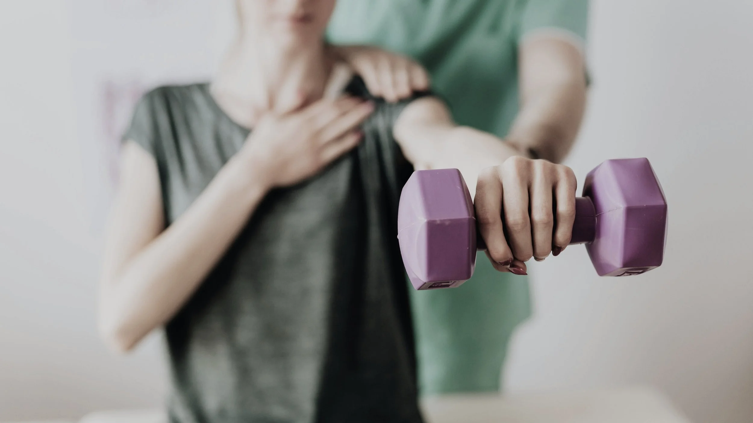 Person holding a purple dumbbell with a hand on their chest, assisting with breathing exercise