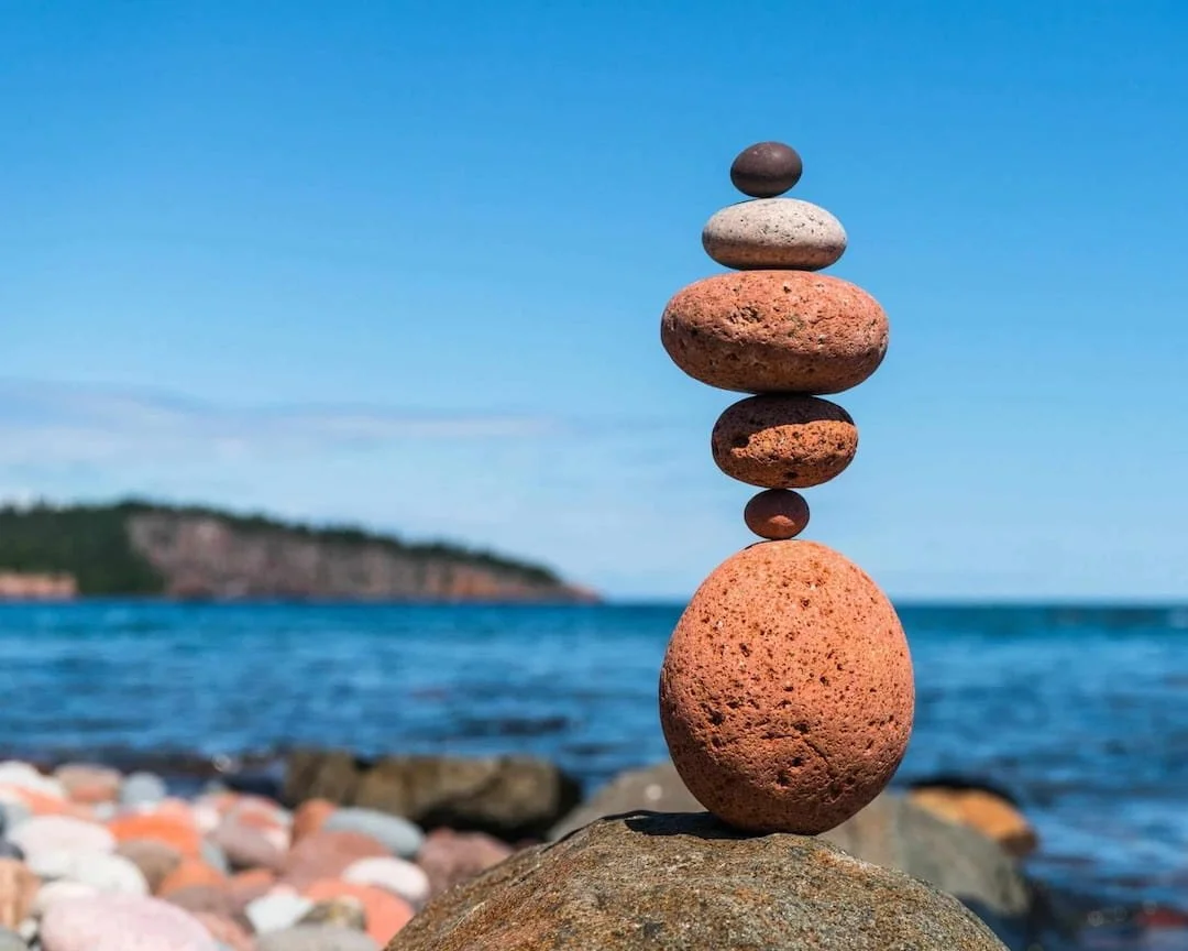stack of roundish rocks next to a body of water