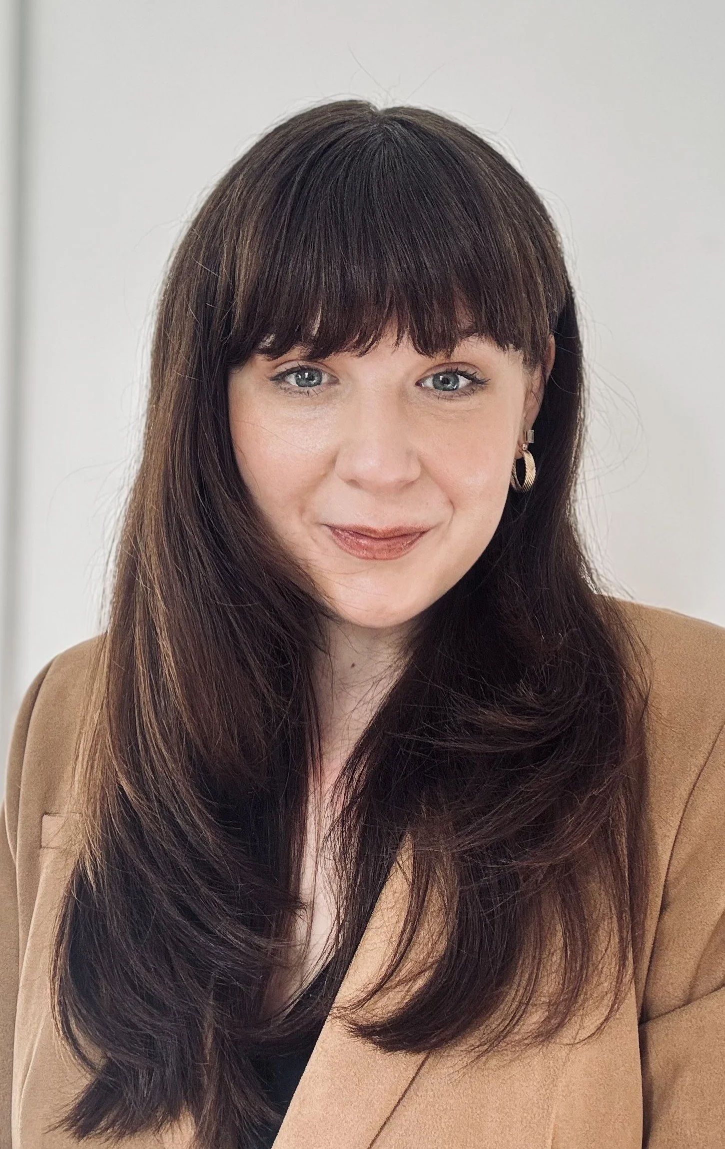 This is a photo of board secretary Erin Salie. She is a younger woman with brown hair and she is wearing gold earrings.