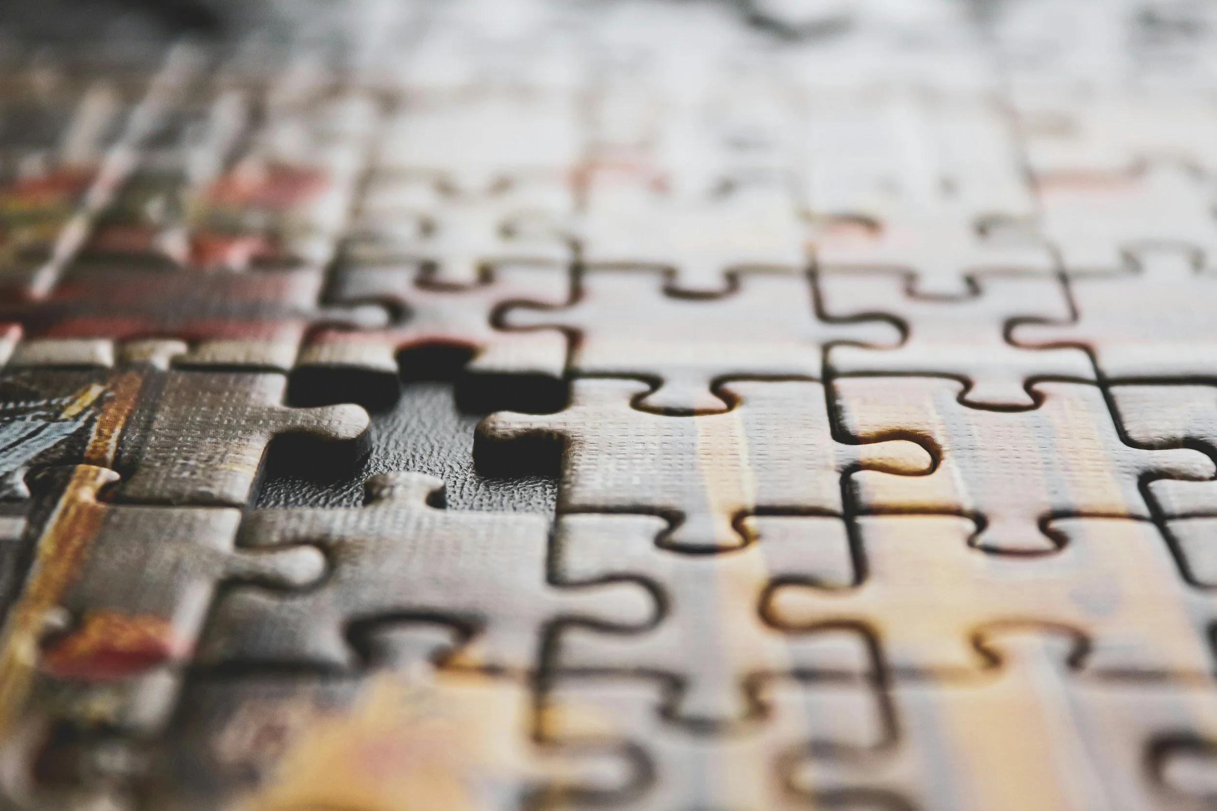 This is a stock image of an almost completed puzzle. There is one piece off to the left side of the image that is missing from the puzzle.