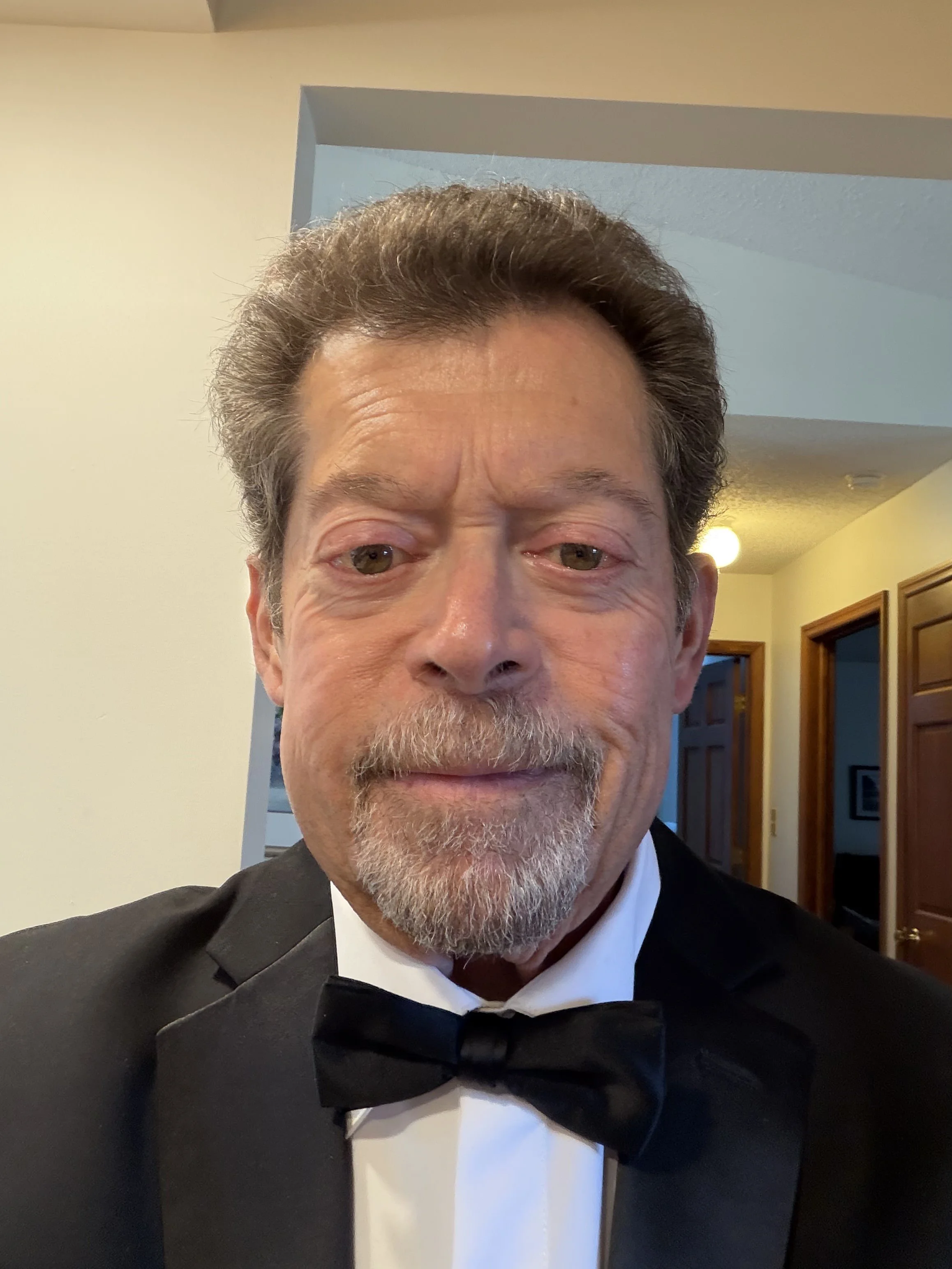 This is a photo of board president Charles Tallent. He is an older gentleman with brown hair and is wearing a black suit. 