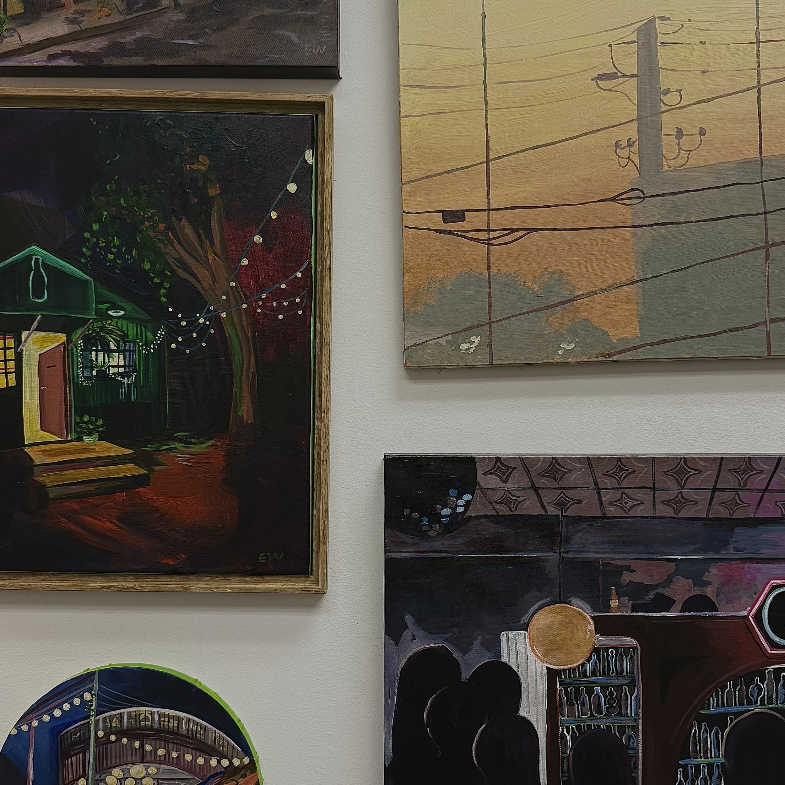 Colorful abstract paintings on a wall, featuring various patterns and scenes, with a mix of dark and vibrant colors.