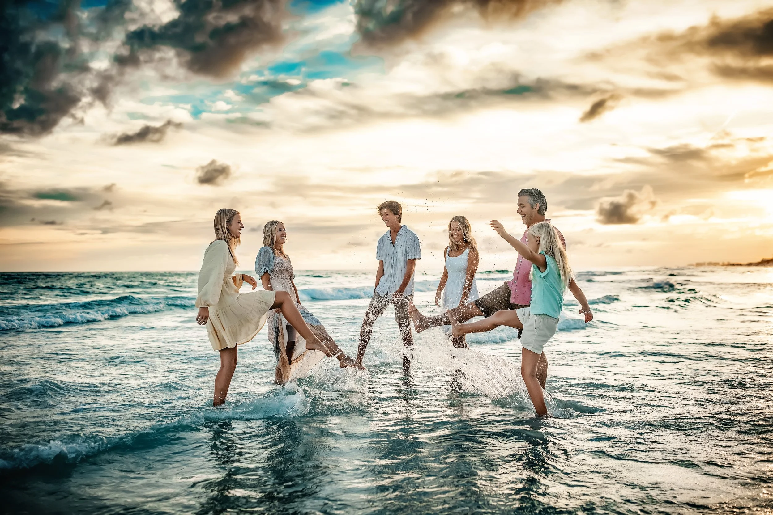 Family of six splashing during their Seaside Family Beach Session in the gulf water
