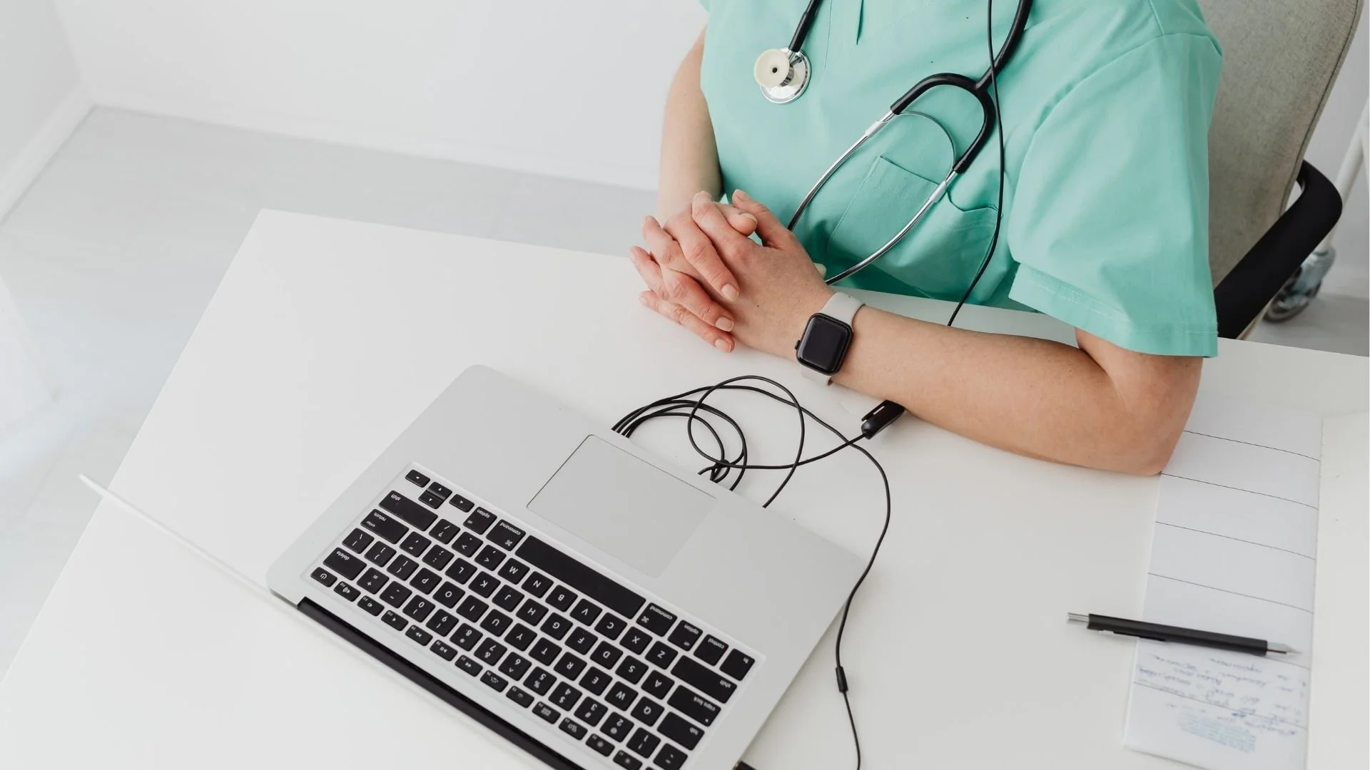 Medical provider sitting at a table with laptop