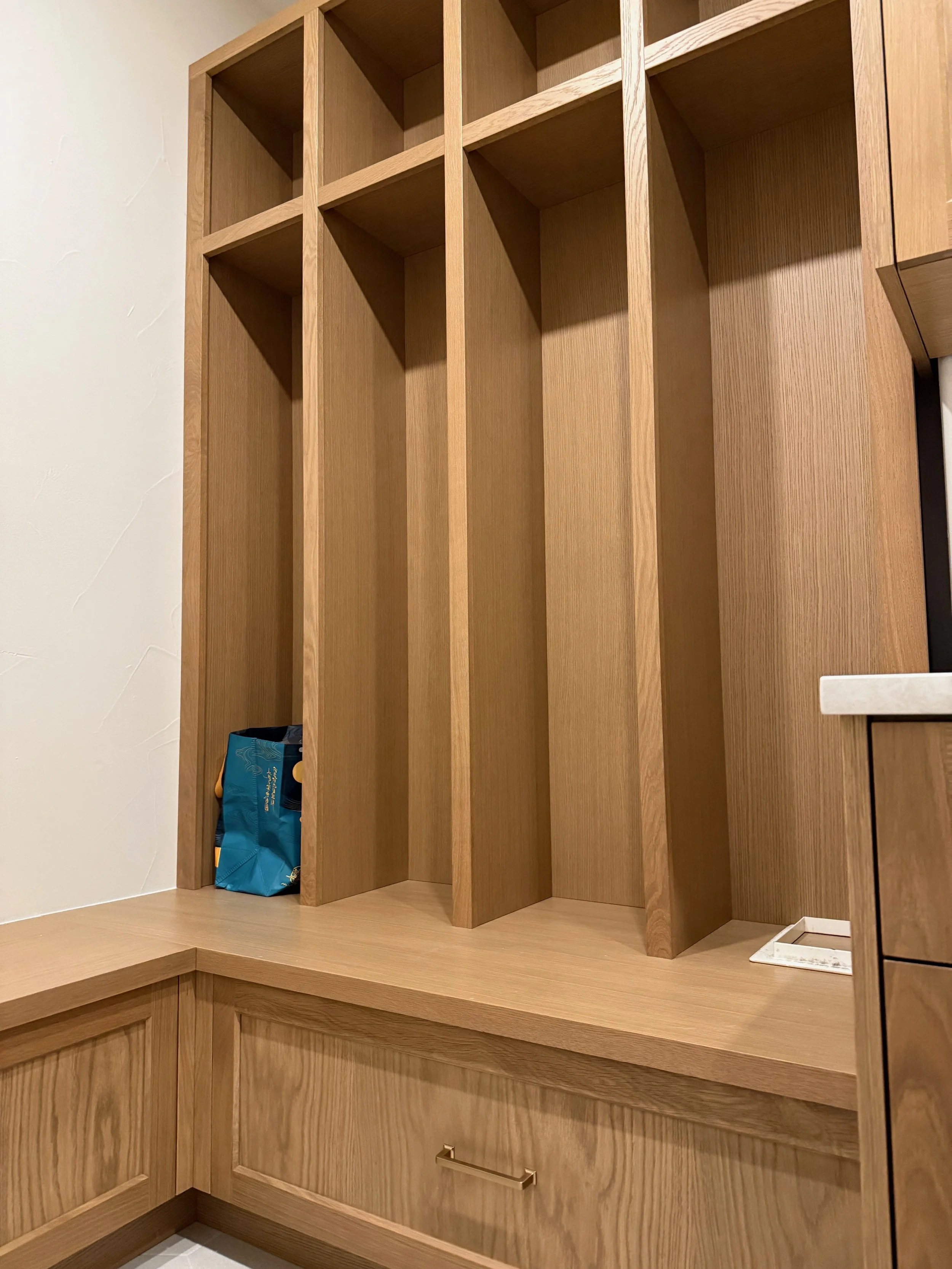 Empty wooden shelves with a single bag and a small dish on the counter.
