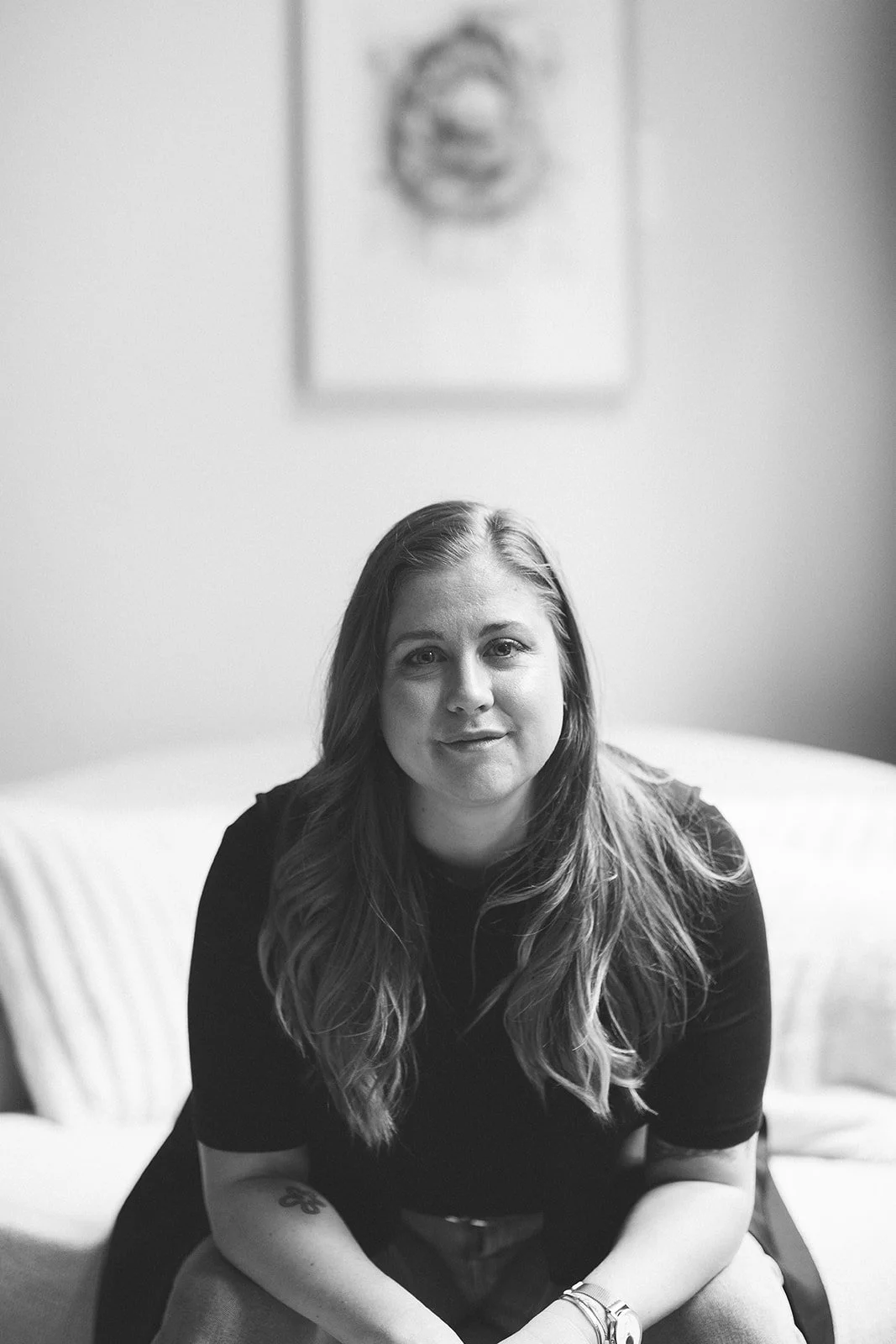 lack and white portrait of Meredith Garreau, founder of Wanderwell Counseling, seated on a couch with a calm and steady expression