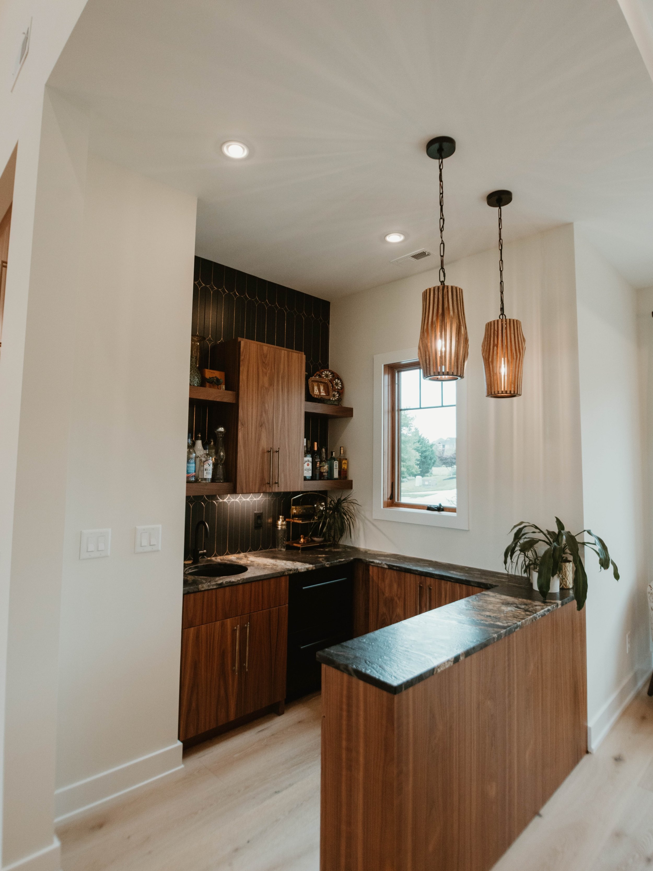 This one-of-a-kind wet bar combines rich walnut cabinetry, dramatic stone countertops, custom lighting, and bold tile detail to create a space that feels both elevated and inviting.🥂

Whether it&rsquo;s hosting friends, celebrating milestones, or en