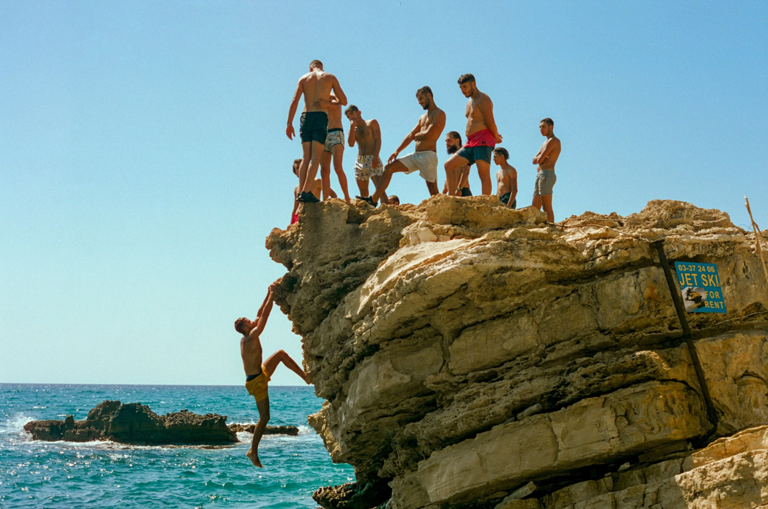 Men Jumping Off Cliff at Joining Beach, Vanessa Smart