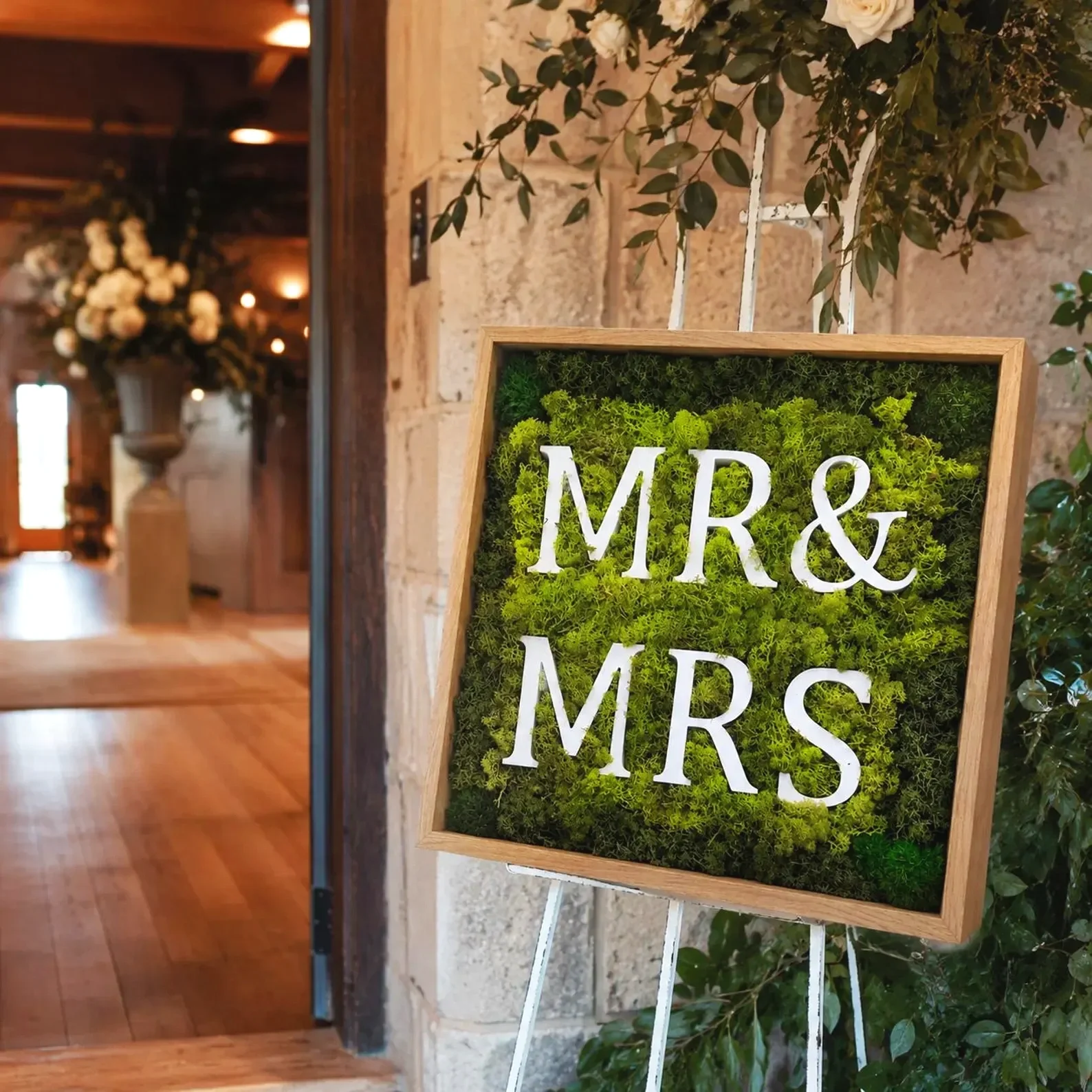 Framed preserved moss wedding sign with Mr & Mrs lettering, styled as natural wedding décor for a ceremony or reception.
