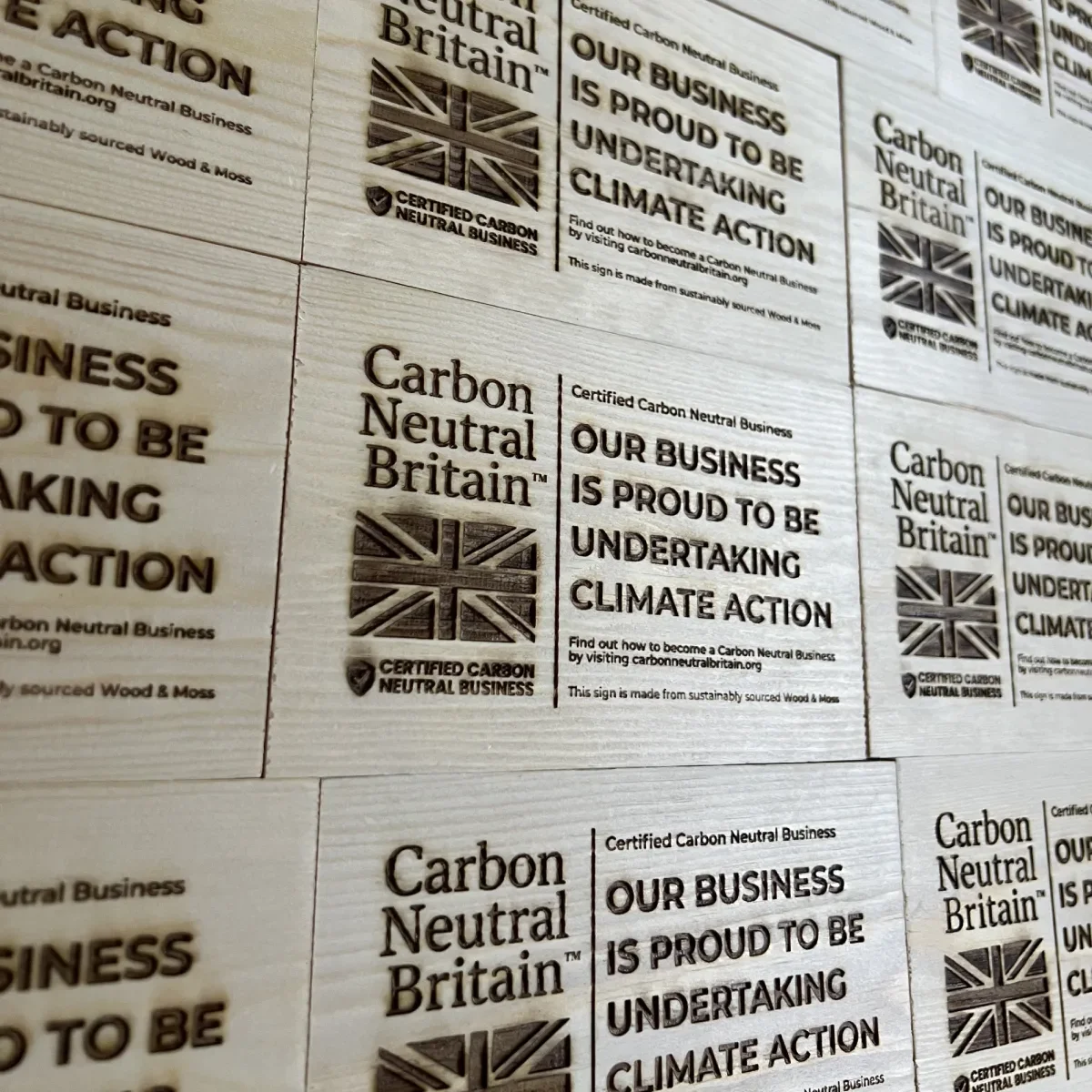 Engraved wooden Carbon Neutral Britain plaques prepared for the preserved moss project.