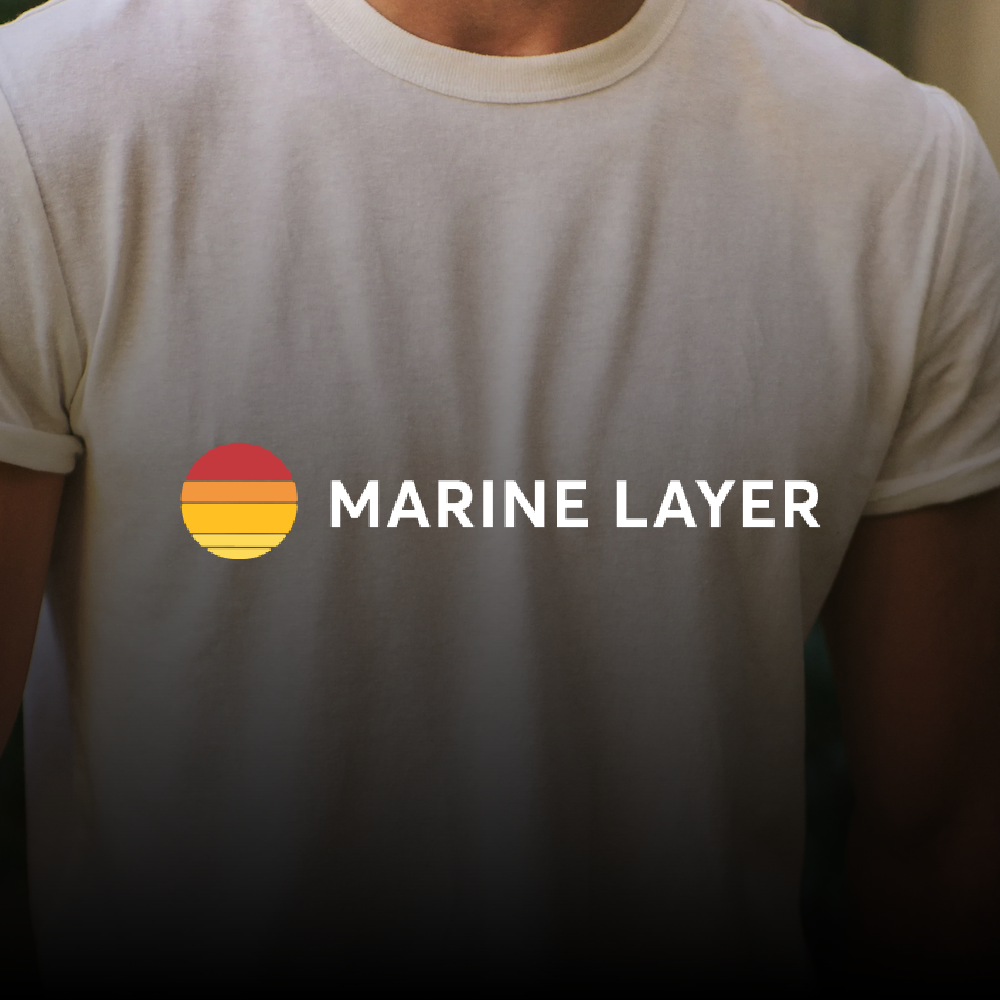 Person wearing a white t-shirt with a Marine Layer logo on it